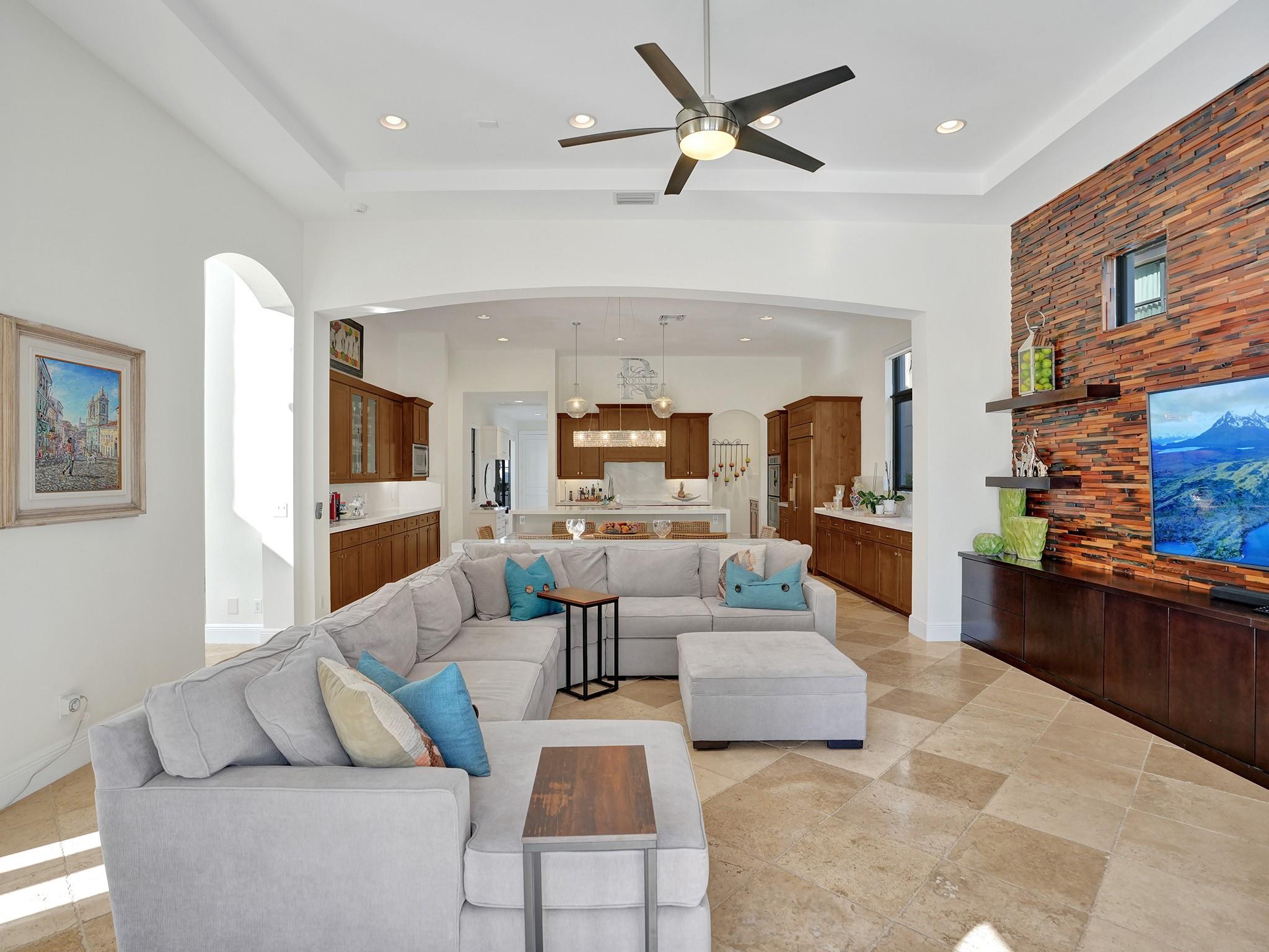The view from the family room extends seamlessly into the dining area and kitchen, all part of expansive, aerial spaces characterized by high ceilings.