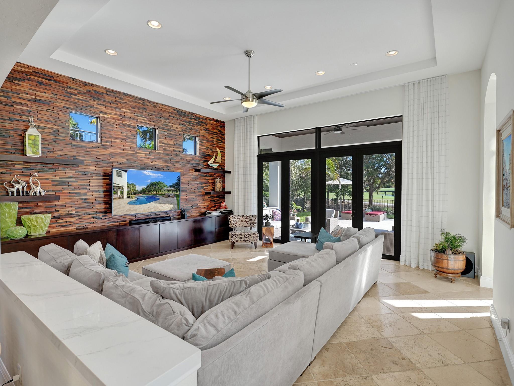 The family room is cleverly separated from the dining area by a small wall with white quartz. This clean and elegant division maintains an open flow between these adjacent rooms.