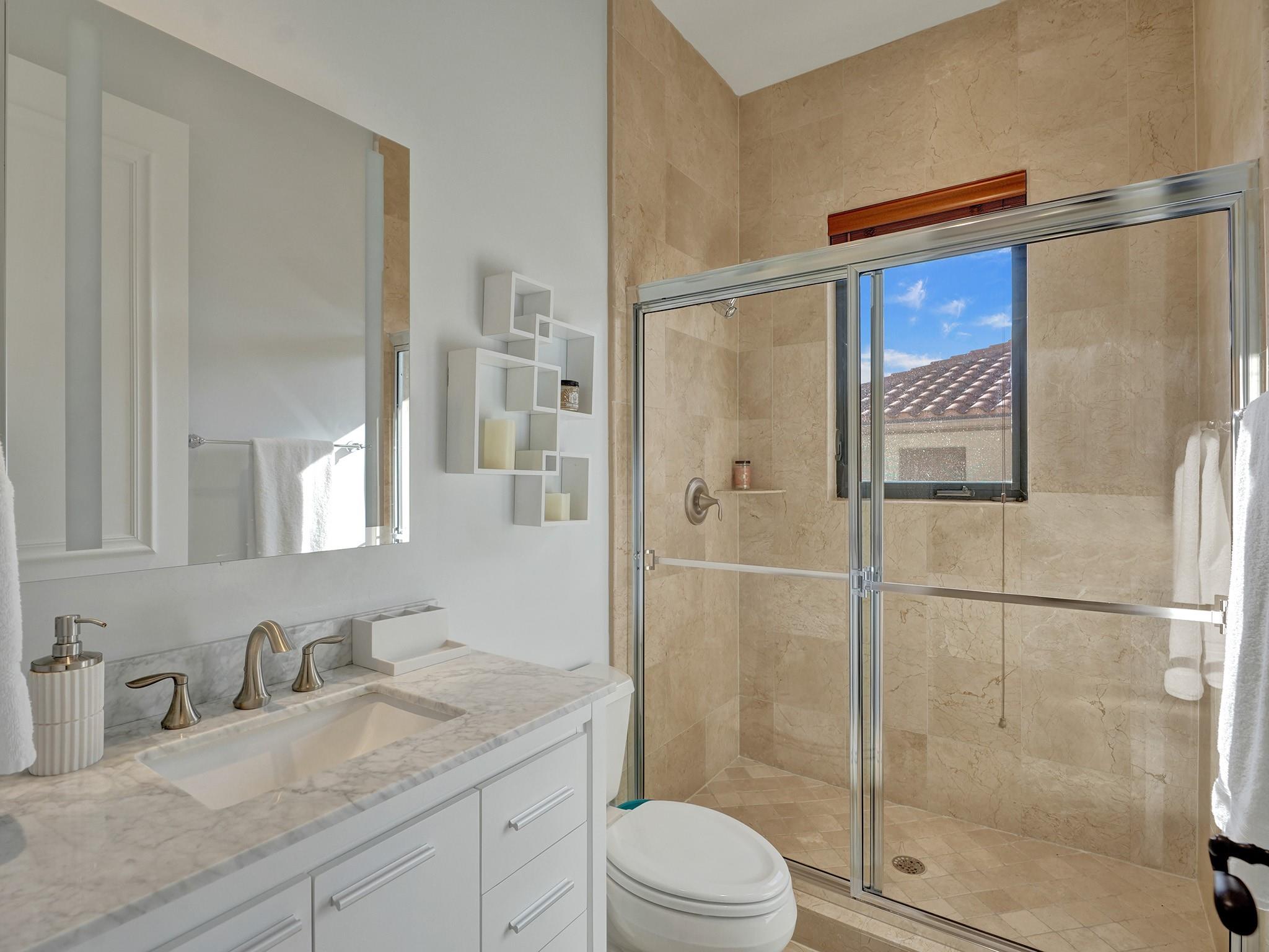 Touches of sophistication: tiles reaching the ceiling in the shower, with a sleek window for refreshing views.