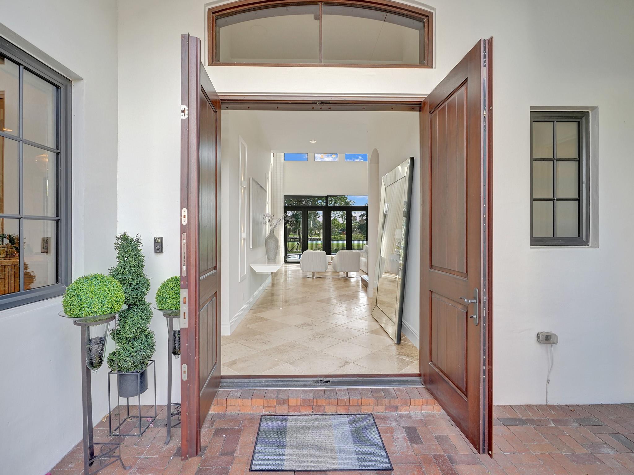 An entrance with a sturdy hurricane-proof wooden door opens to a spacious living room with a stunning immediate view.
