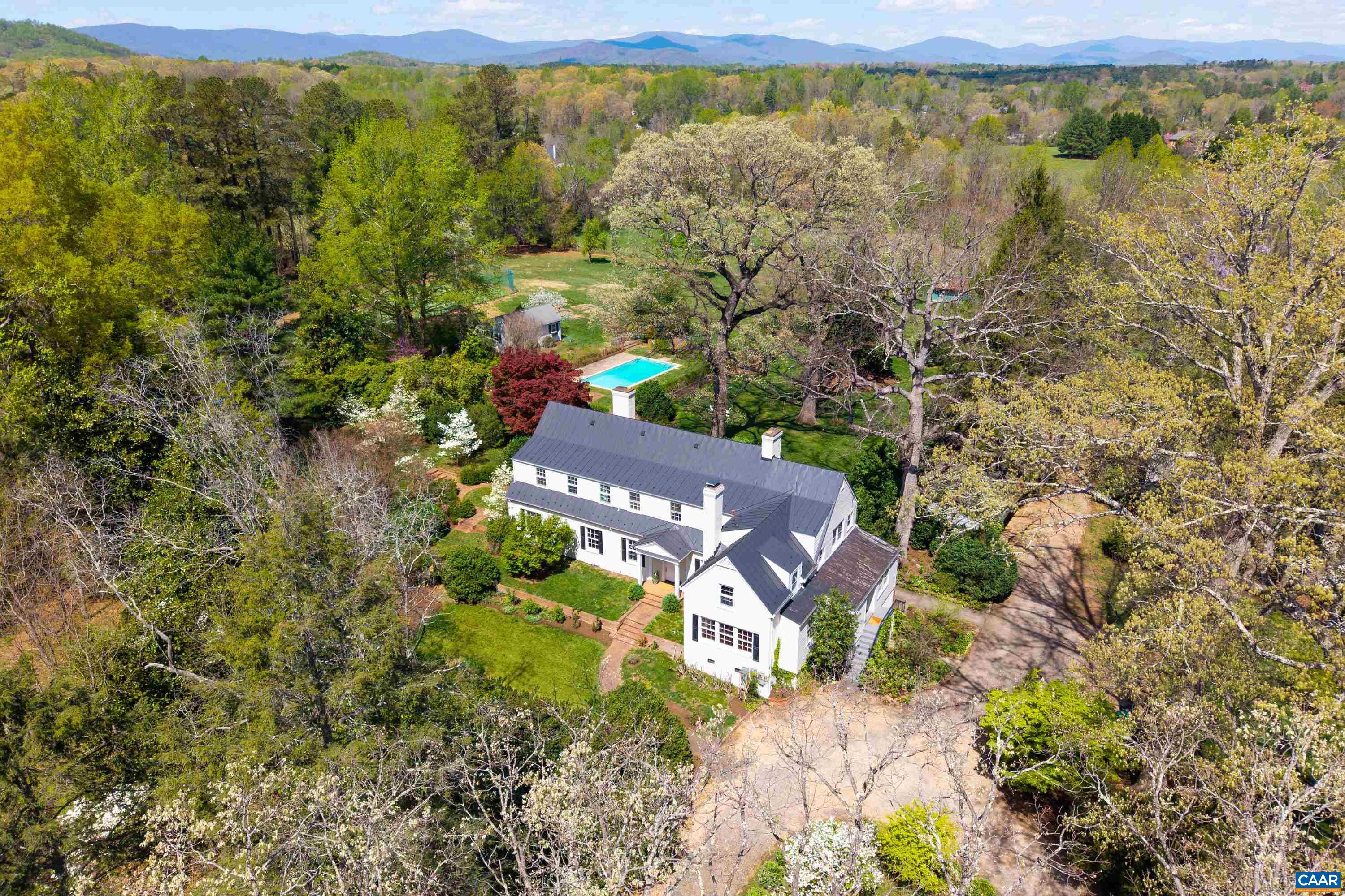 Robin Hill- An Exclusive Retreat in Ivy, Just Minutes from Charlottesville and UVA. Nestled on a magnificent 4.11-acre estate that embodies the essence of historic English homes, Robin Hill presents a rare opportunity to own a stunning brick residence in a highly sought-after location. This exceptional property blends modern luxury with timeless architectural elegance. Upon entering, you are welcomed by a grand entrance hall leading to a spacious great room, ideal for both entertaining and relaxing. The dining room, featuring a fireplace, exudes sophistication, while the updated kitchen connects seamlessly to a cozy library/media room and a sun-drenched porch, perfect for enjoying morning coffee. The upper level includes a luxurious primary suite and three additional en suite bedrooms, providing ample space for family and guests. The estate is enhanced by a refreshing pool surrounded by mature trees, a lovely blue slate patio, a guest house, a four-car garage, and a versatile barn, all contributing to its unique character. Offering an unmatched blend of elegance, comfort, and convenience in a picturesque setting, Robin Hill is not just a home; it’s a lifestyle.