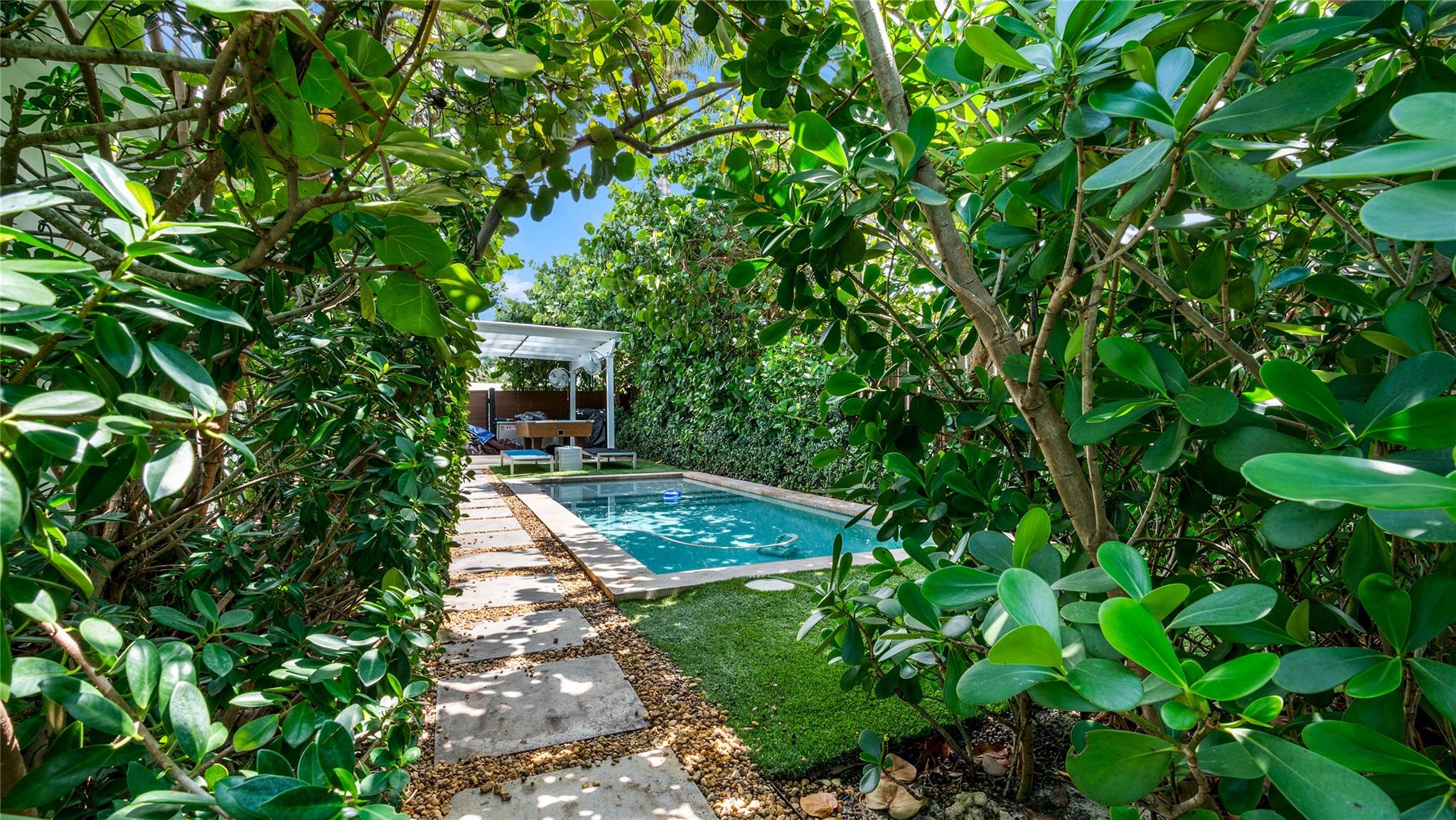 Saltwater pool enveloped by lush privacy-enhancing landscaping
