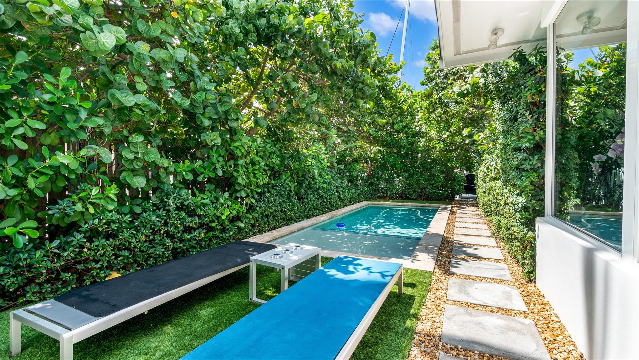 Saltwater pool enveloped by lush privacy-enhancing landscaping