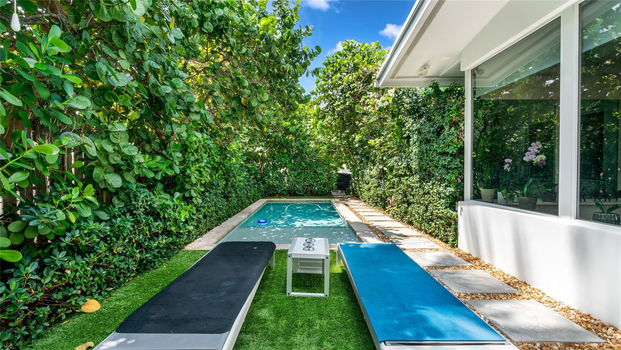 Saltwater pool enveloped by lush privacy-enhancing landscaping