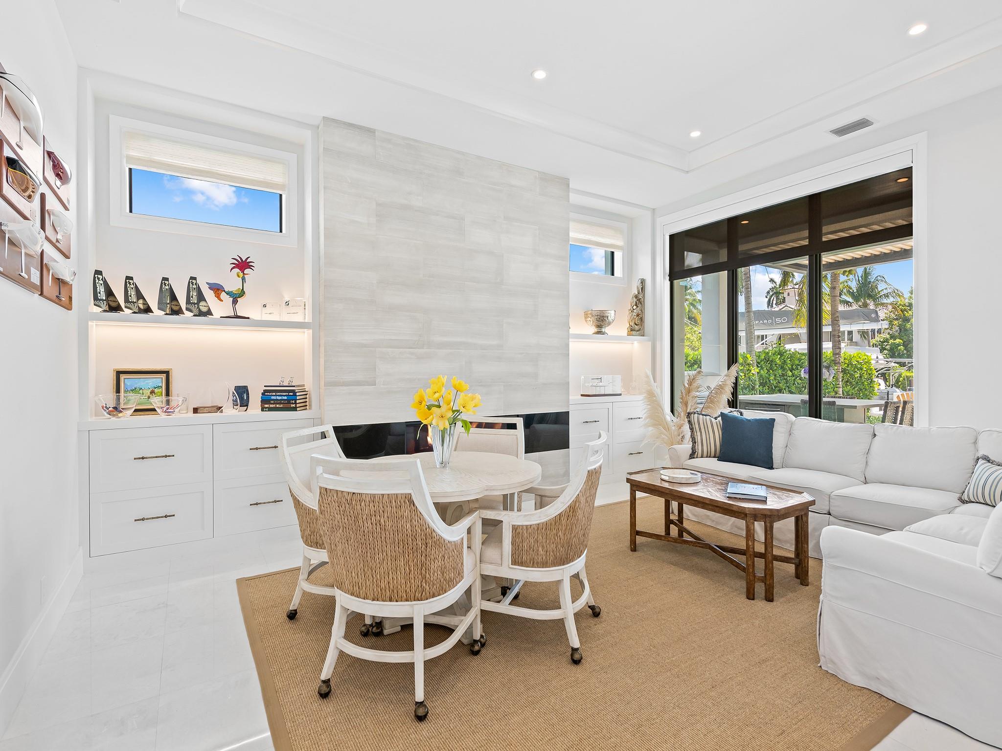 Stunning custom built-in bookshelves frame a sophisticated fireplace, creating a warm and elegant focal point in the living space