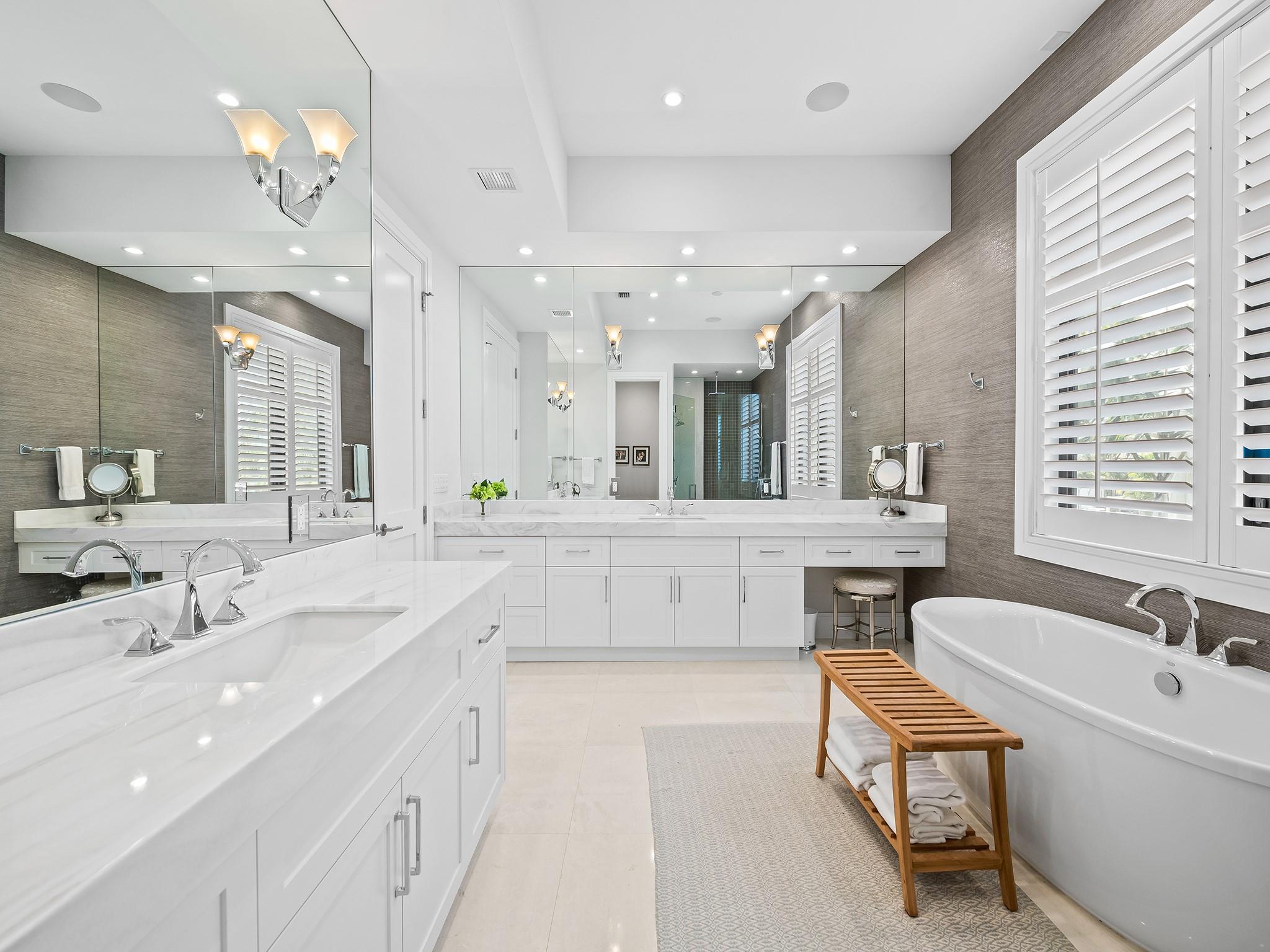 Luxurious primary bathroom, complete with double vanities, a freestanding tub, a private toilet room, and a spacious shower