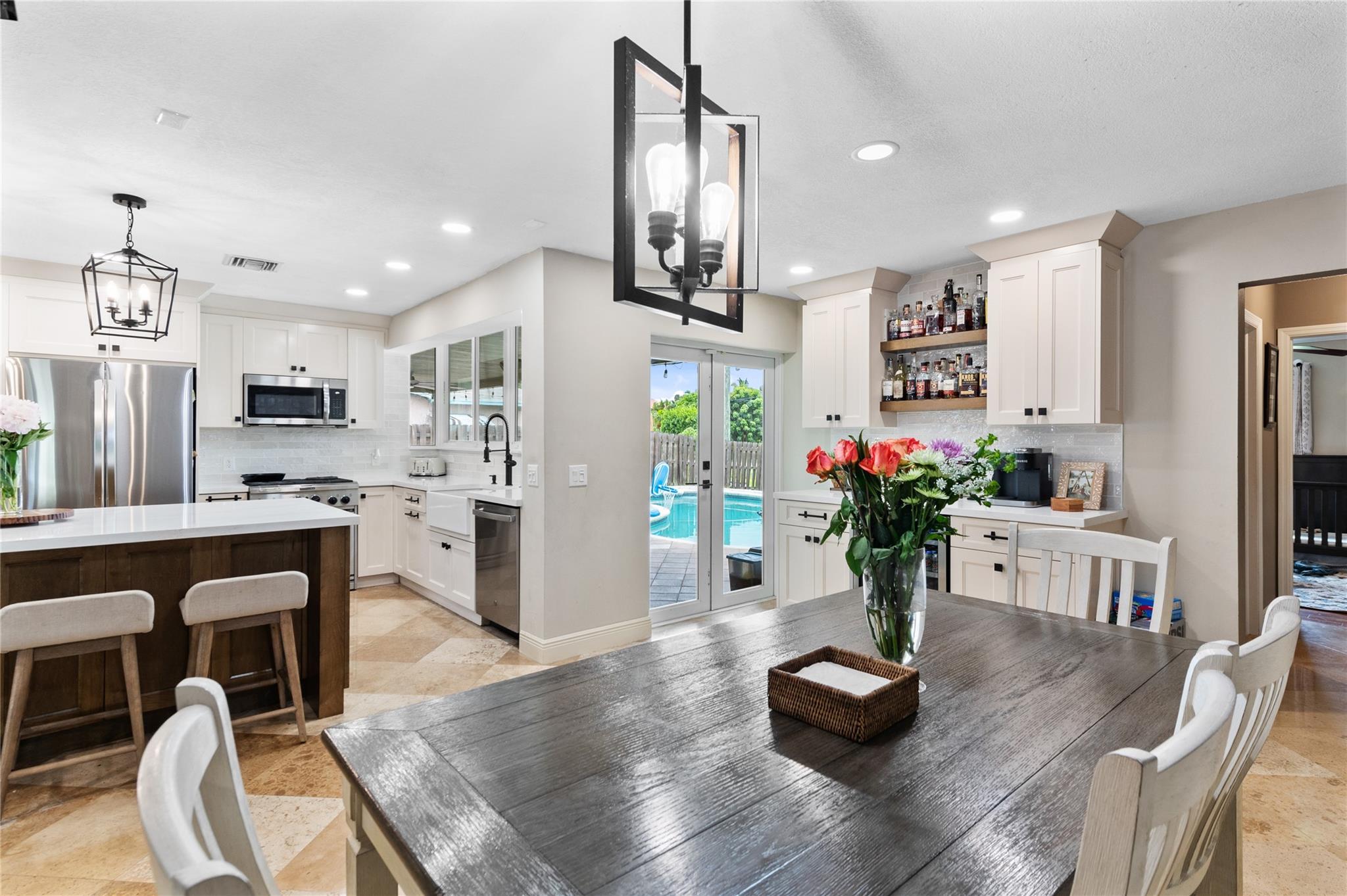 overlooking the kitchen, coffee/wine bar, and access to patio/pool/backyard area