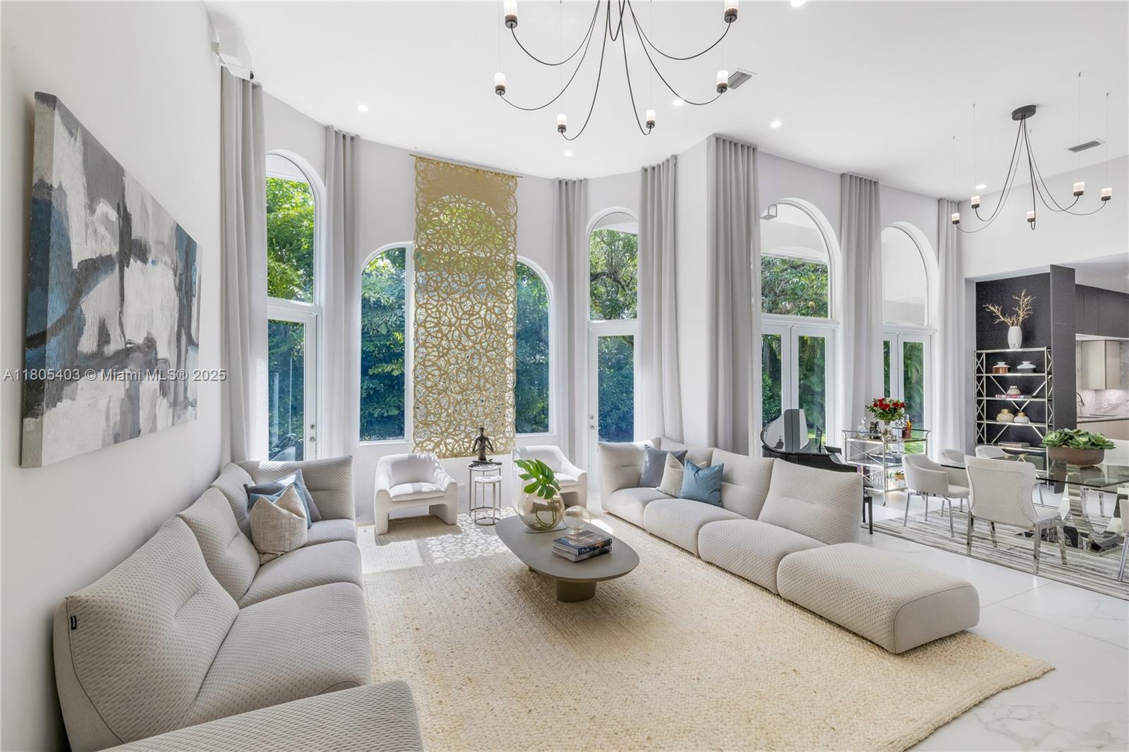Best and most convenient location in Pinecrest. Set behind gates on a peaceful cul-de-sac in North Pinecrest, this refined single-story estate presents a rare opportunity to own a private compound steps from the newly completed Gary Matzner Park. On 1.1 acres of mature, manicured grounds, the property offers privacy, scale, & timeless appeal. The residence encompasses 6,318 square feet of living space with 6 bedrooms & 5-and-a-half baths, designed with an emphasis on flow, light, & understated luxury. Firenze Carrara marble floors extend throughout & new wood floors in bedrooms/closets are complemented by new impact glass that frames tranquil garden views & fills the interiors with natural light. The kitchen is architectural & functional, with Veneta Cucine Italian cabinetry, a sculptural leather-textured marble island, & Miele professional-grade appliances—ideal for intimate dining or sophisticated entertaining. The primary suite is conceived as a serene retreat, offering dual walk-in wardrobes & a spa-level bath finished in full-height, single-slab Italian stone. The Kohler DTV+ digital wellness system delivers steam, chromotherapy, integrated audio, & lighting. A 2 story guesthouse with new wood floors & a large bedroom on the ground floor & office on the 2nd floor provides exceptional comfort for extended family or long-term guests. A second driveway will fit a boat or large vehicle with ease. Outdoor living with a pool, new summer kitchen, & expansive garden await.
