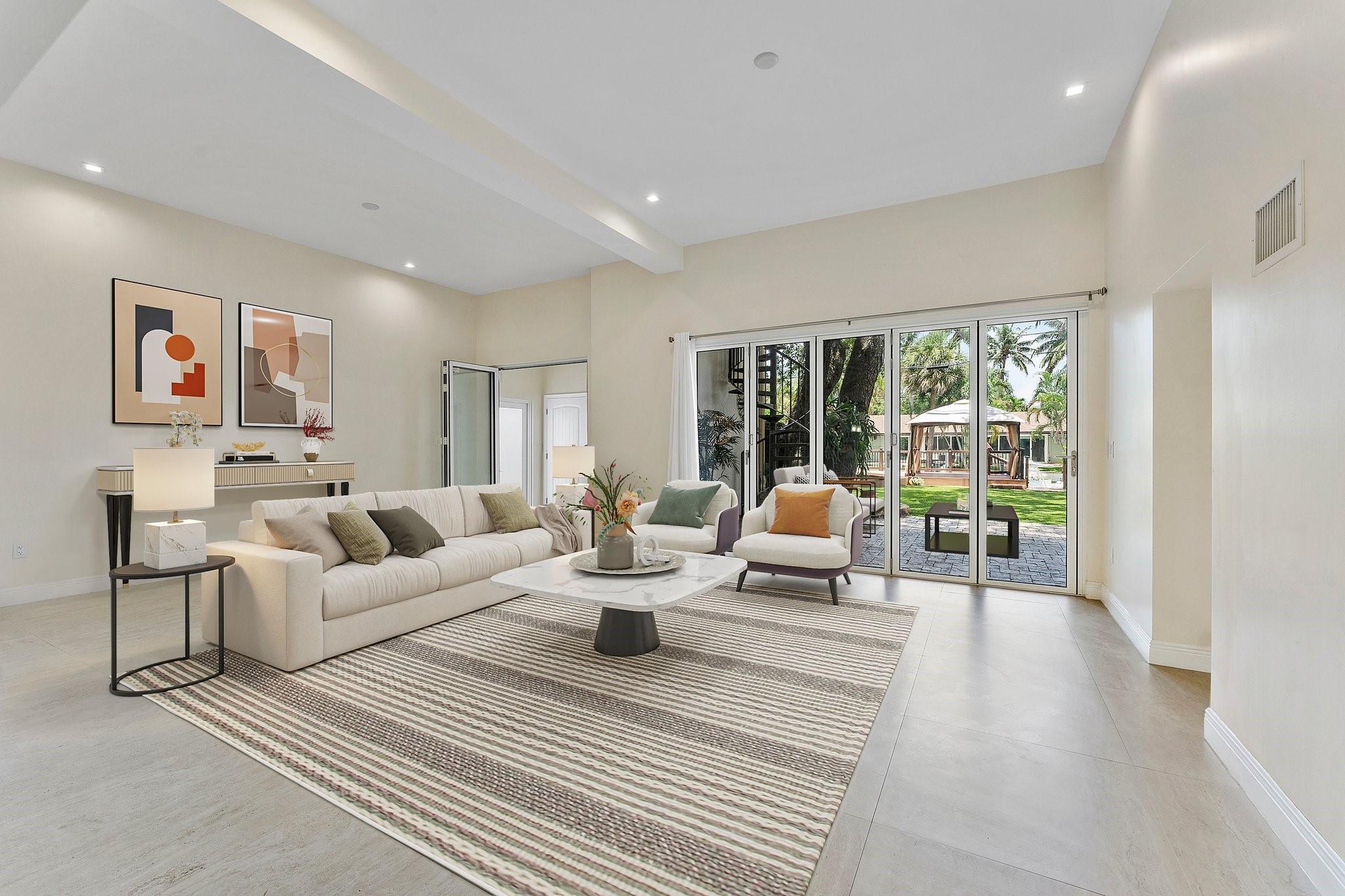 over sized family room with accordion impact doors to backyard. Volume ceiling height virtually staged