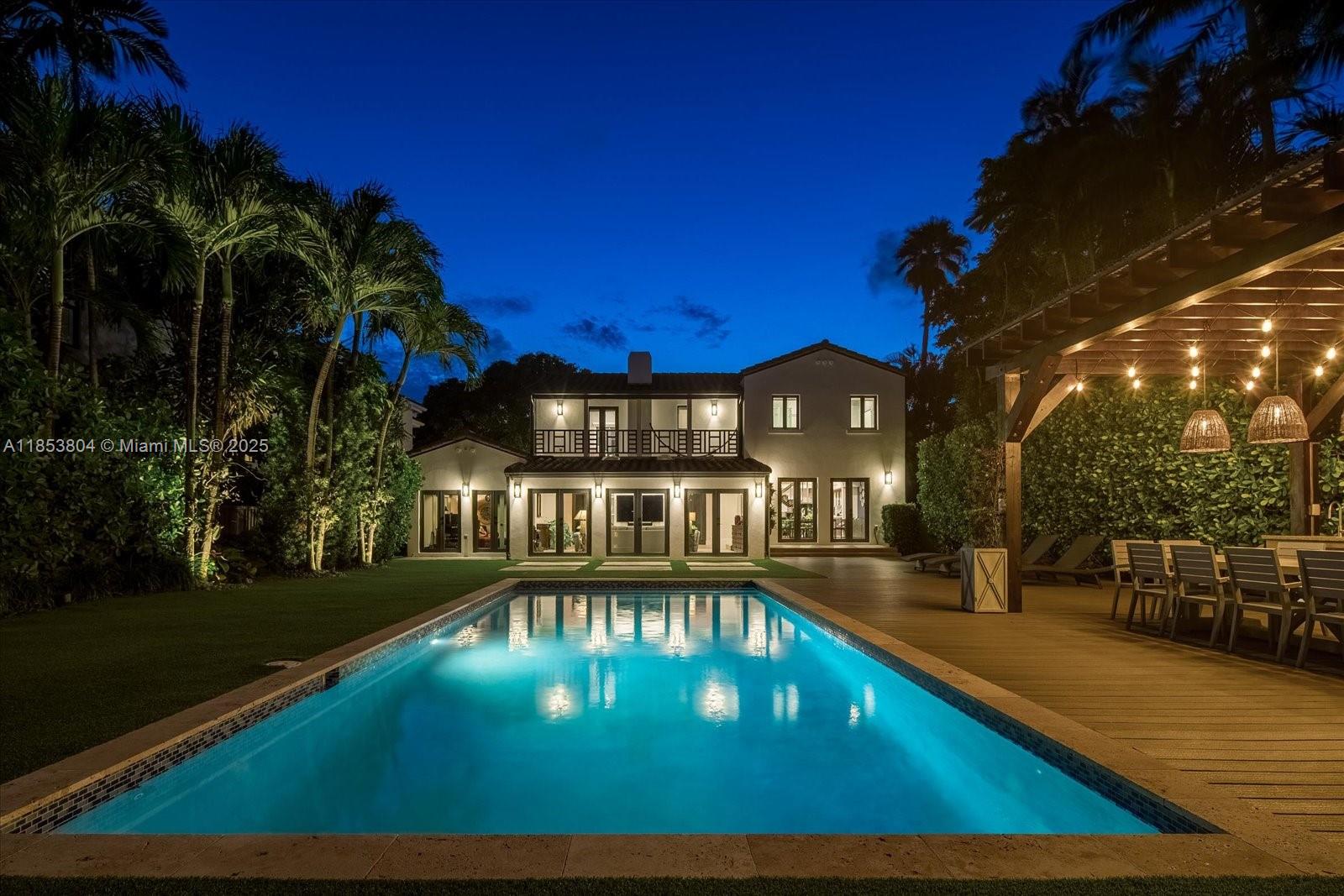 Timeless design meets tropical living at Villa D’Amore, a reimagined 1920s estate blending historic character with modern comfort. Set on a 9,856 SF lot, this 4BD/4BA home offers 3,800 SF indoors and 928 SF of outdoor living. Features include original pine ceilings, wide-plank oak-style floors, preserved encaustic cement tiles, and custom millwork throughout. A restored fireplace anchors the great room, while floor-to-ceiling impact glass frames palm-lined courtyards and water views. The chef’s kitchen includes a marble waterfall island and Thermador appliances. The upstairs primary suite offers a private terrace, oversized shower, and soaking tub. Outside: heated lap pool, pergola summer kitchen with pizza oven, and new wood deck.