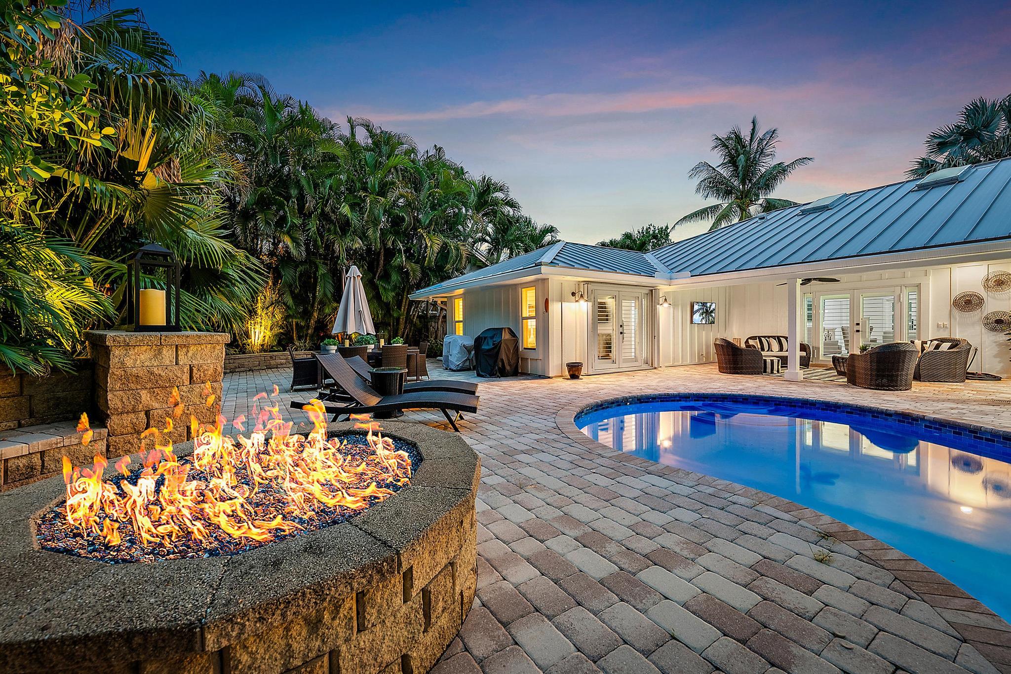 Just bring your bathing suit and toothbrush to this elegantly re-imagined, completely remodeled and furnished coastal inspired beach escape. This homes transformation was focused on opening the space and transforming the home to a elegant beach retreat.  The new living area includes a vaulted family room with shiplap, beam ceilings, and board and a batten focal wall . A large designer kitchen with custom micro shaker cabinetry was designed by Zimmermans kitchens. The beautiful, expansive island with luxury appliances and quartz counters makes perfect for entertaining and family gatherings.  The Primary suite was redesigned with a larger bathroom and closet area. The spa-like bathroom is an oasis with a luxurious shower, a free-standing soaker tub, upgraded fixtures and vanity. There is an attached toilet room.  A junior suite was added with an expanded walk-in closet and cabana bath. The home also has two additional bedrooms sharing a newly renovated bathroom. The true gem of this home is the beautiful and spacious backyard. This outdoor space includes a large updated pool and spa, gas fire pit, gas torches, large covered lanai with tv, expansive patio with landscape lighting, sprinkler system, and lush private tropical landscape.
The home comes furnished, turnkey and its move in ready for the upcoming season and to live your best life in the amazing beachside town of Jupiter, Fla. 

The home was renovated in 2023-2024 with these additional highlights: 
"New kitchen with built in commercial refrigerator, Bosch induction range with hood, Bosch island microwave, new dishwasher and all new high-end cabinetry, quartz counters and backsplash.  A large island with quartz and seating was also added
"Hidden pantry with shelved murphy door
"Renovated master bedroom with spa bathroom and luxury closet including a washer and dryer
"Impact windows added throughout the house (with the exception of the large back window) 
"New impact front door
"House painted inside and out
"Updated front entry to modernize the house and curb appeal