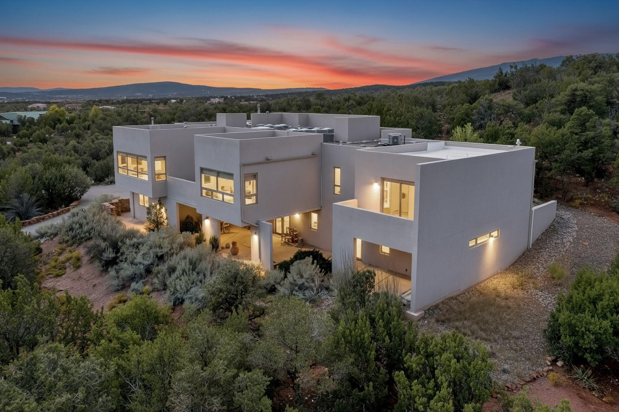 A rare opportunity awaits in Paako--an exclusive retreat where luxury, privacy, and mountain serenity converge. Home showcases panoramic views of the San Pedro, Ortiz and Sangre de Cristo mountains framed by spacious windows and open floor plan perfectly sited on 3+ acres. Every upgrade reflects meticulous care and lasting quality: Brazilian granite and cherry kitchen, ceramic tile flooring, Navien hydronic tankless system, professionally engineered gutter drainage system, curated landscaping including gated drive and fruit trees. Architect-designed addition has 20x30' artist's studio with separate entrance and private deck; repurpose for multigenerational living, second primary or family room. Homes of this caliber are seldom offered--an exceptional experience best appreciated in person.
