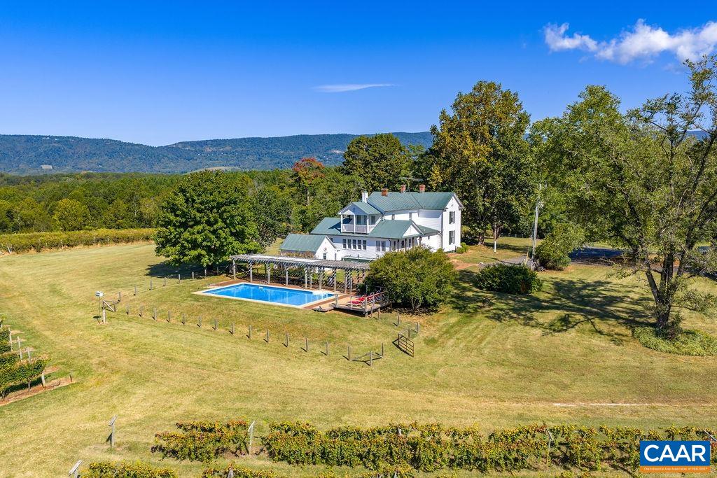 Centrally located in the Monticello AVA, and in the center of the Nelson 151 Craft Beverage Trail, Cardinal Point Vineyard & Winery has been in business since 1985. Surrounded by breathtaking Blue Ridge Mountain views, this well established family run 81 acre winery is ready for its next owner. The heart of the property is the classic 5 bedroom 1890s farmhouse. Featuring gleaming original hardwood floors, period fixtures, dual primary suites, stunning cherry kitchen, sunroom, and inground pool, the house is currently operated as a hugely popular short term rental. Of the ~35 open acres 7 are in established vineyard production, with 4 acres currently fallow and ready for new vines. The winery features a contemporary 1080sqft tasting room with office & restrooms, seating in the indoor mezzanine/outdoor covered deck/patio, and 2880sqft of production and storage space. Public amenities also include an outdoor stage, disc golf, and open space for picnicking & play. The property is supported by numerous outbuildings including a 5040sqft open equipment shed with work and storage spaces as well as a conditioned office. The house and winery are both fully energized by solar power, the house also has generator back-up. Opportunities abound!