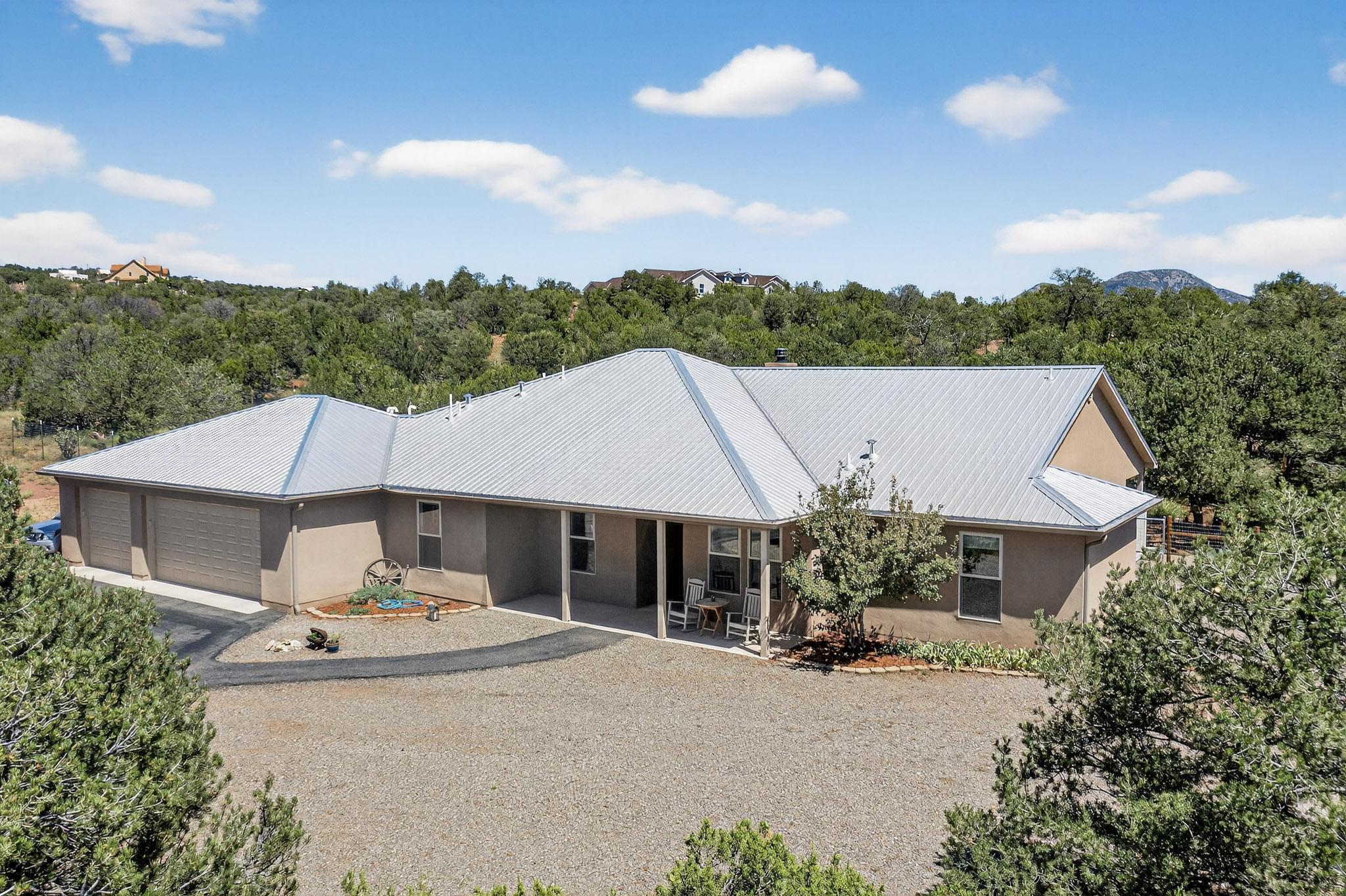 Nestled on a 2.04-acre wooded lot, this stunning single-story 4-bedroom, 3-bathroom home blends comfort with luxury. Designed for everyday living & entertaining, the chef's kitchen boasts granite countertops, custom hickory cabinetry with pull-outs, induction cooktop, double ovens, instant hot water, reverse osmosis at the sink, & a walk-in pantry. The inviting great room is anchored by a custom stacked-stone wood-burning fireplace, while the spacious primary suite offers built-in shelving & a spa-inspired bath with dual vanities, a soaking tub, & a walk-in shower. Outdoors, relax under the covered patio or in the included hot tub, all within a fenced enclosure. Additional highlights include a huge 3-car garage with storage, refrigerated air, & the convenience of included appliances.