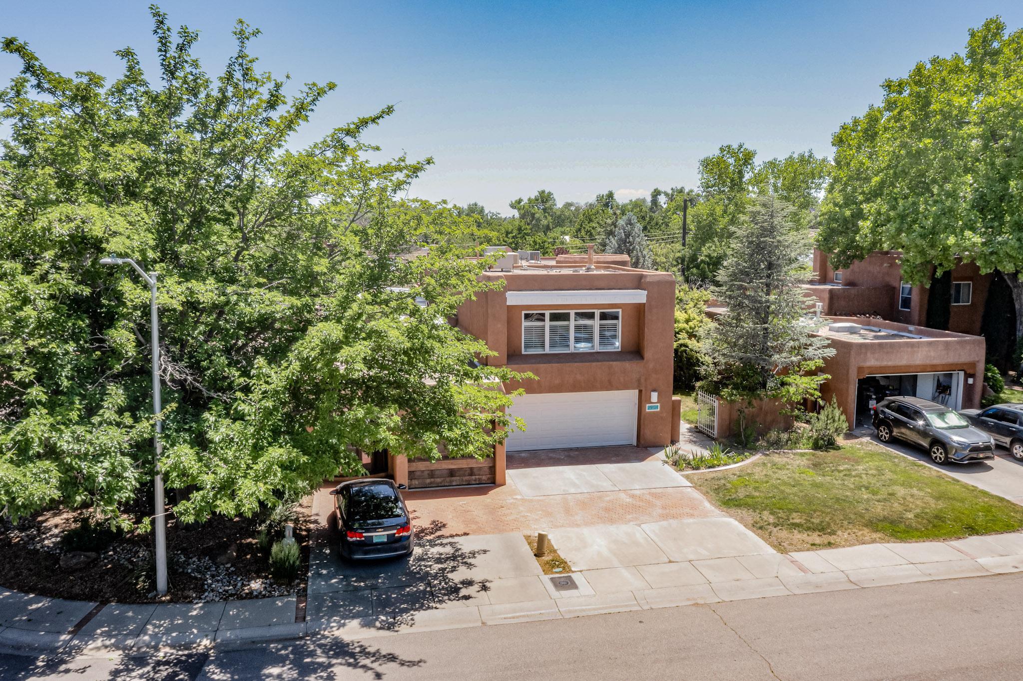 Quiet, private, community just a stone's throw from the Bosque. Neighborhood is filled with SW architecture and loaded with CHARM. Enter the gated courtyard, and be greeted with lush trees, shrubs, and flowers. Once inside - circular foyer with soaring ceilings and hand carve beams that extend into the living room will WOW you! Window wall and french doors to the patio allow lots of natural light and looks out into a backyard oasis. Formal dining off the living leads to a stunning kitchen remodel and breakfast nook - also looking out back. Downstairs bedroom includes french doors and easy bathroom access. Circular staircase leads to a huge primary bedroom and an additional ensuite bedroom including an office. Don't miss this great opportunity for Valley Living!