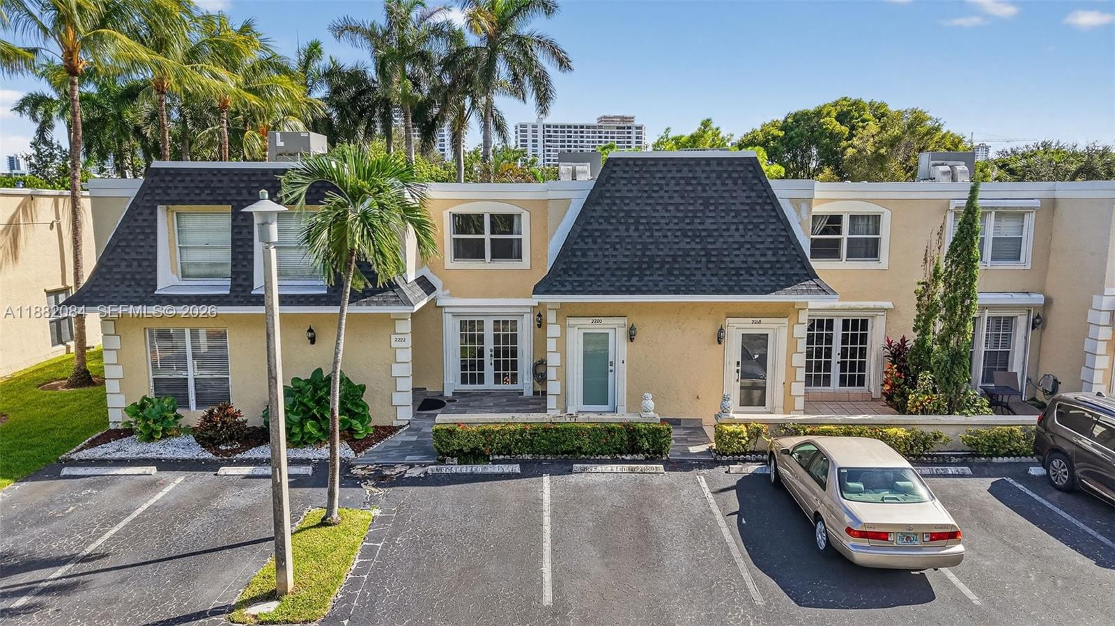 Limited Time Offer: $5,000 closing-cost credit to the Buyer at Closing for a full-price offer submitted and accepted by February 2nd, 2026! Open House - February 1st, 1-3 PM. Best value and best location in the highly desirable Three Islands community—this beautiful 2-bedroom, 2.5-bath townhome offers an exceptional opportunity for both primary owners and investors, with the ability to rent immediately after purchase. Located in the sought-after Venetian Townhomes West community, it has been significantly upgraded, including a new 2024 roof, hurricane-impact windows and doors, new A/C, new refrigerator, new second-floor flooring, fresh interior paint, updated window treatments, and newly resurfaced front and back patios. A brand-new motorized outdoor awning enhances the private outdoor space. Ideally positioned within the community, the spacious fenced backyard opens directly to Three Islands Park, offering instant access to playgrounds, basketball courts, and scenic walking paths—an extension of your living space. Residents enjoy resort-style amenities including a heated pool, tennis courts, and clubhouse, while maintenance conveniently includes water, cable, and internet. The seller paid off the remaining assessment in full. Just minutes from the beach, shopping, dining, and major airports, this move-in-ready townhome delivers the perfect balance of lifestyle, location, and immediate income potential.