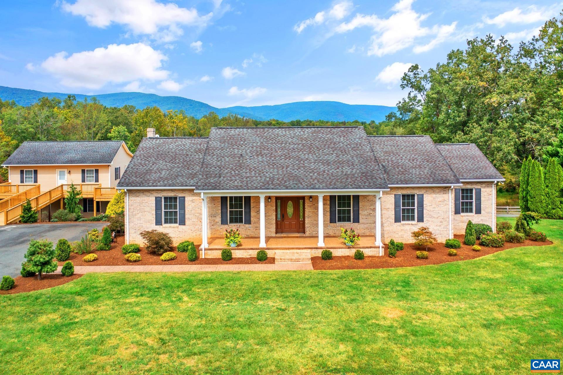 Discover this exceptional 5 bedroom, 4 bath home nestled in beautiful Albemarle County, where over 12 acres of breathtaking mountain views await. Meticulously maintained, this property offers stunning hardwood floors and a custom oak kitchen complete with a cozy breakfast nook and a generous pantry. The spacious walk-in laundry room features a utility sink for added convenience.   With two full kitchens and a terrace level entry, this home is perfect for accommodating guests or in-laws. The inviting family room features soaring cathedral ceilings adorned with wood beams, creating a warm and welcoming atmosphere throughout.   Enjoy the benefits of a detached garage with a workshop area and a reliable full house generator. Freshly painted and surrounded by mature landscaping, this home showcases incredible curb appeal. The wrap-around deck on the garage is perfect for outdoor entertaining, while the potential for a 6th bedroom, home office, or gym offers endless possibilities. Don’t miss your chance to own this versatile and beautifully appointed home!