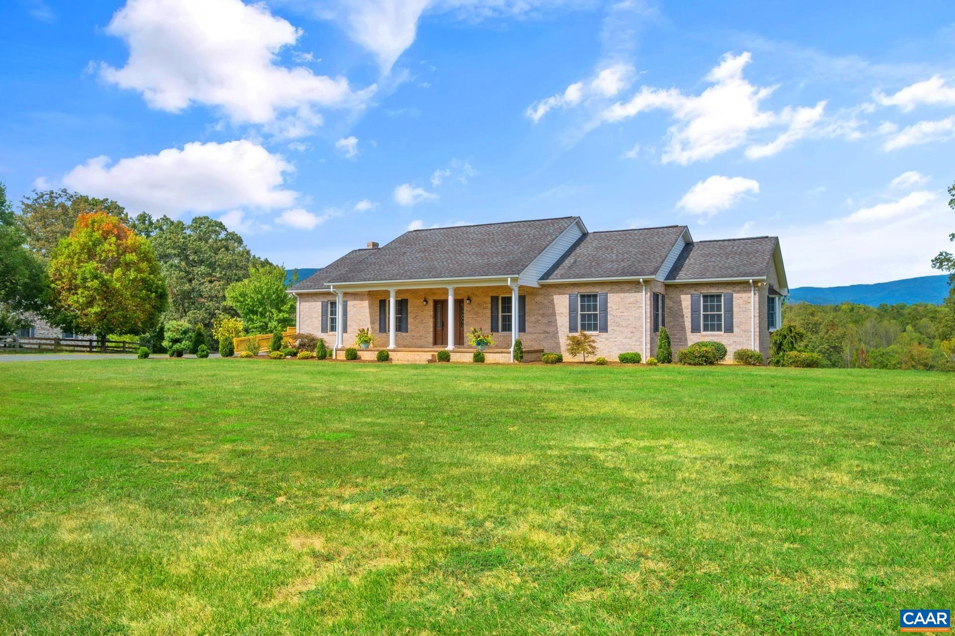 Experience the charm of this stunning 5-bedroom, 4-bath home nestled in the picturesque Albemarle County, set against a backdrop of over 12 acres featuring spectacular mountain views. This meticulously maintained residence boasts elegant hardwood flooring and a beautifully crafted oak kitchen, complete with a cozy breakfast nook and a spacious pantry.  The convenient walk-in laundry room is equipped with a utility sink, making daily chores a breeze. Designed with versatility in mind, this home includes two fully equipped kitchens and a terrace-level entry, making it ideal for hosting guests or accommodating in-laws.  Step into the inviting family room, where soaring cathedral ceilings and rustic wood beams create a warm, welcoming environment. Additional features include a detached garage with a workshop area and a dependable full-house generator. Freshly painted and surrounded by mature landscaping, this home possesses remarkable curb appeal.  The wrap-around deck on the garage is the perfect spot for outdoor gatherings, and there’s also potential for a 6th bedroom, home office, or gym—limitless possibilities await! Seize the opportunity to make this exceptional and beautifully designed home yours today!