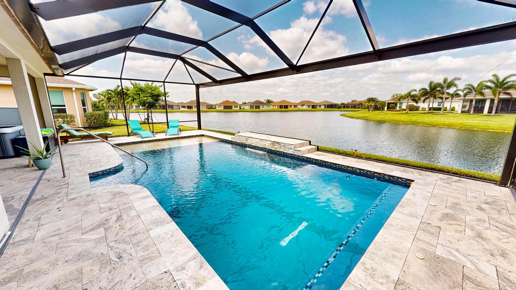 2BR + Den, 2BA home with breathtaking lake and pool views! This beautifully upgraded residence features a spacious, open layout with a huge family room--perfect for entertaining. The gourmet kitchen is a chef's dream with a gas cooktop, dual wall ovens, soft-close drawers, and brand-new refrigerator and microwave. Enjoy peaceful outdoor living on the extended, screened lanai with elegant travertine flooring and an oversized, solar-heated saltwater pool overlooking the water. The large primary suite offers custom closets, dual sinks, and a walk-in shower. Throughout the home, you'll find custom closets, designer fans, and upgraded lighting. Additional features include impact glass, a barrel tile roof, and thoughtfully designed upgrades throughout. Don't miss this one!