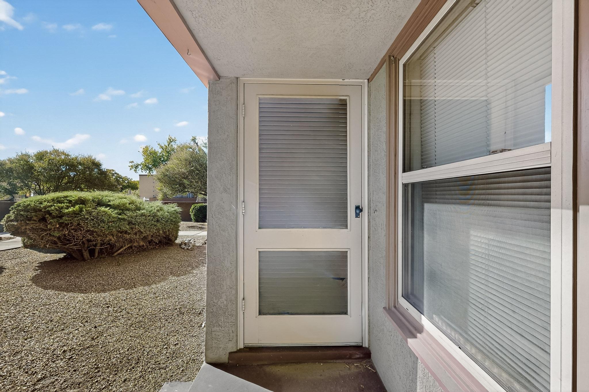 Don't Miss the opportunity to live close to downtown!!! Beautiful condo close to Albuquerque Country club! This property has gorgeous old school charm. A wood accent wall in the living room, with a wood beam accent separating the living room and dining room. Hard wood floors throughout the entire condo. Generously sized master bedroom and secondary bedroom. Two step-in closets in the master bedroom. Stackable W/D in the kitchen. This unit boasts lots of light throughout for plenty of natural lighting! Storage space closet attached to the carport space. HOA covers sewage, water, trash, outdoor maintenance, landscaping, and winterizing/summarizing the swamp cooler. Property management company oversees the HOA. Stucco newly repainted and newer roof 2024. Make an appointment today