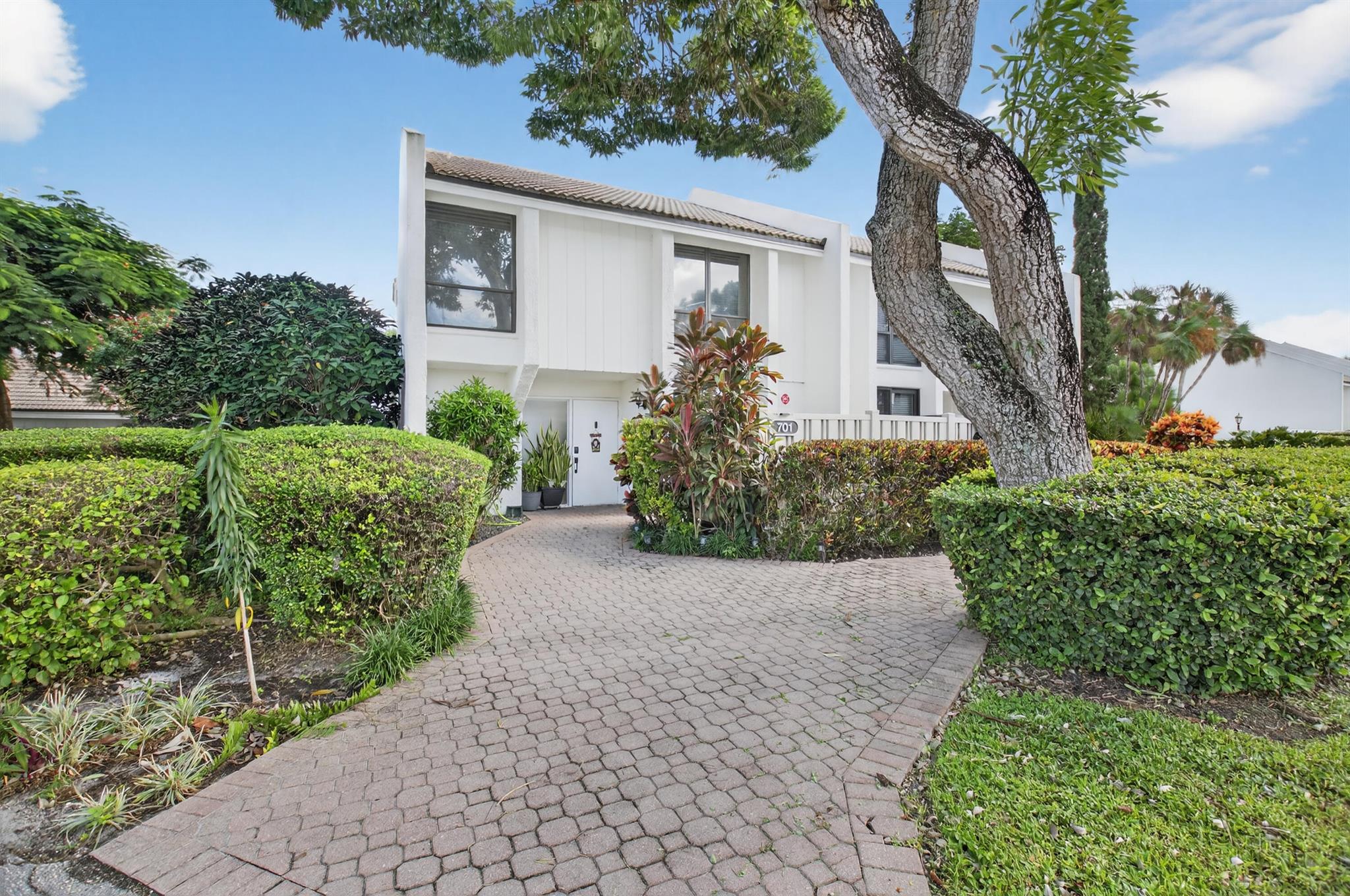 Bridgewood 3 bedroom, 2.5 bath town house. Corner lot  with lushly landscaped exterior patio area with partial lake view. Expanded interior area with porch glassed in and opened to the living area. Renovated interior with engineered wood floors throughout. Updated kitchen with granite counters, stainless appliances and kitchen drawers with lights. Oversized washer & dryer. LED Lights in all the rooms. All the bathrooms have been updated with new vanities, toilets and flooring. Tankless water heater. Water filter. No popcorn. Fitted Closets. Private barbecue and sitting area off the kitchen which could be a golf cart area.  Comes with a covered parking space. A/C replaced in 2021.  New Electrical panel. Club req'd at $150,000. + dues & $10,000 Capital Cont.  to the   B.W. Master Assoc.