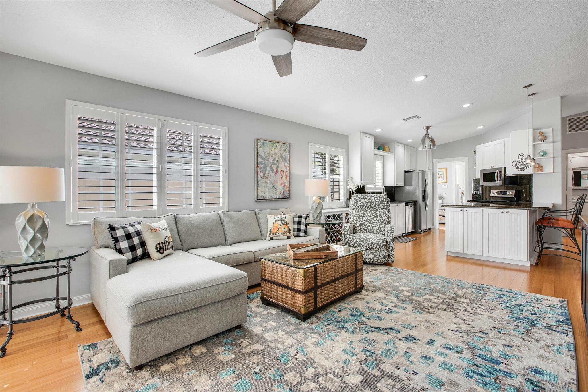 Beautifully maintained 2BR/2BA POOL home with 2-car garage in a sought-after lakefront community. This Capri model stands out with its private screened pool, dining/lounging patio, and covered lanai overlooking the water. The open-concept living and dining areas flow to a granite kitchen with newer appliances, while the split floorplan offers two bedroom suites with walk-in closets and renovated baths. Additional features include hardwood, porcelain tile, and laminate flooring, a formal dining room with built-ins, plantation shutters throughout, separate laundry, and abundant linen storage. The guest suite is enhanced with a Murphy bed plus custom desks and cabinetry. For  peace of mind: the home just passed a 4-point inspection (available for transfer), owner has a current wind mit and WDO treatment bond, plus a brand-new monitored ADT wireless alarm system with motion, window, and door, plus fire detection was installed this year. Community amenities include clubhouse, fitness center, tennis, pickleball, and pool. The maintenance fee covers cable, WiFi, lawn care, and security, making this a low-stress, amenity-rich lifestyle.