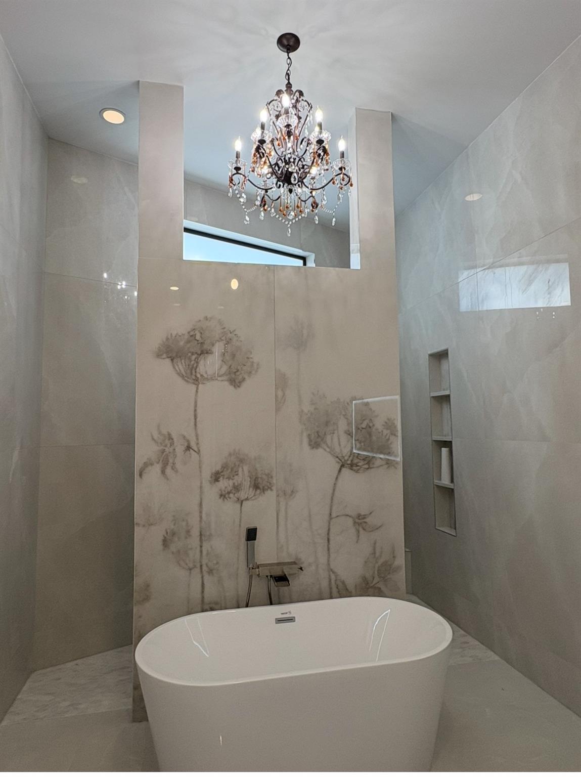 Gorgeous Chrystal chandelier in private
 bathroom with tile slab. Two shower panels behind the bathtub wall. A must see
