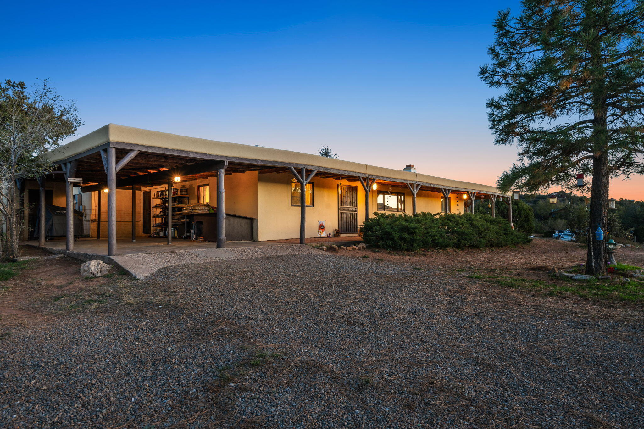Discover your mountain retreat in the desirable Sandia Knolls subdivision! This charming single-story 4-bedroom, 3-bath home offers 2,267 sq ft on a .46-acre wooded lot with stunning Sandia Mountain views. Interior highlights include tongue-and-groove ceilings, brick and laminate flooring and 2 fireplaces. The great room opens to the kitchen with bar seating and a cozy breakfast nook, creating the perfect space for gatherings. The primary suite features a sitting area, wood stove and wet bar, while a second ensuite bedroom provides guest comfort. Outdoors, unwind on the covered front porch and enjoy the fully fenced yard. Two-car carport, 10 x 16 storage shed, graded RV parking, community water, 1 yr old tertiary septic system. A peaceful escape blending rustic charm and modern comfort!