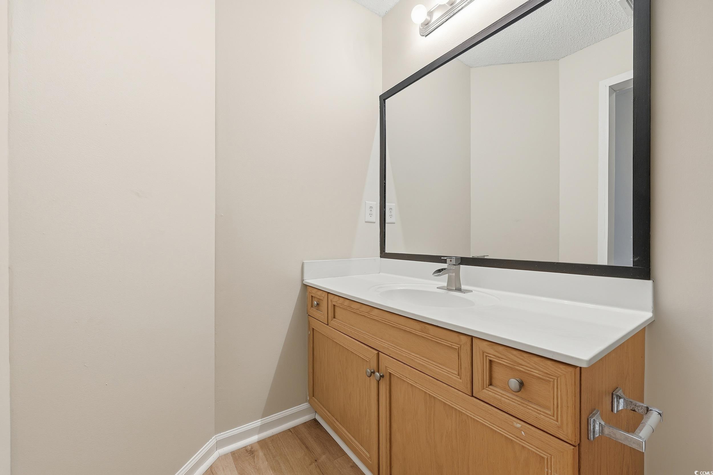 Half bathroom featuring vanity and light wood finished floors