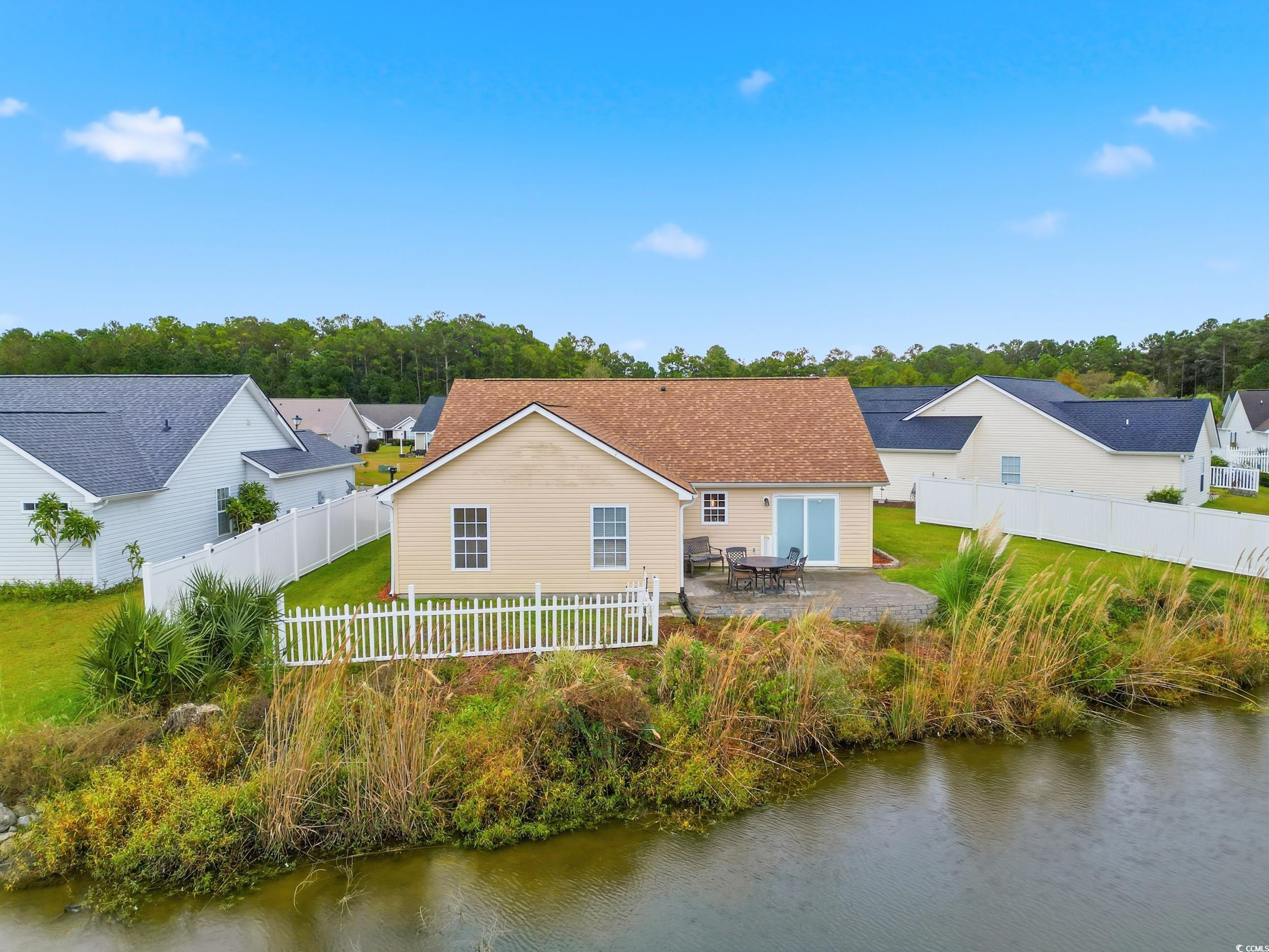 Back of house with a patio, a water view, and a fenced backyard