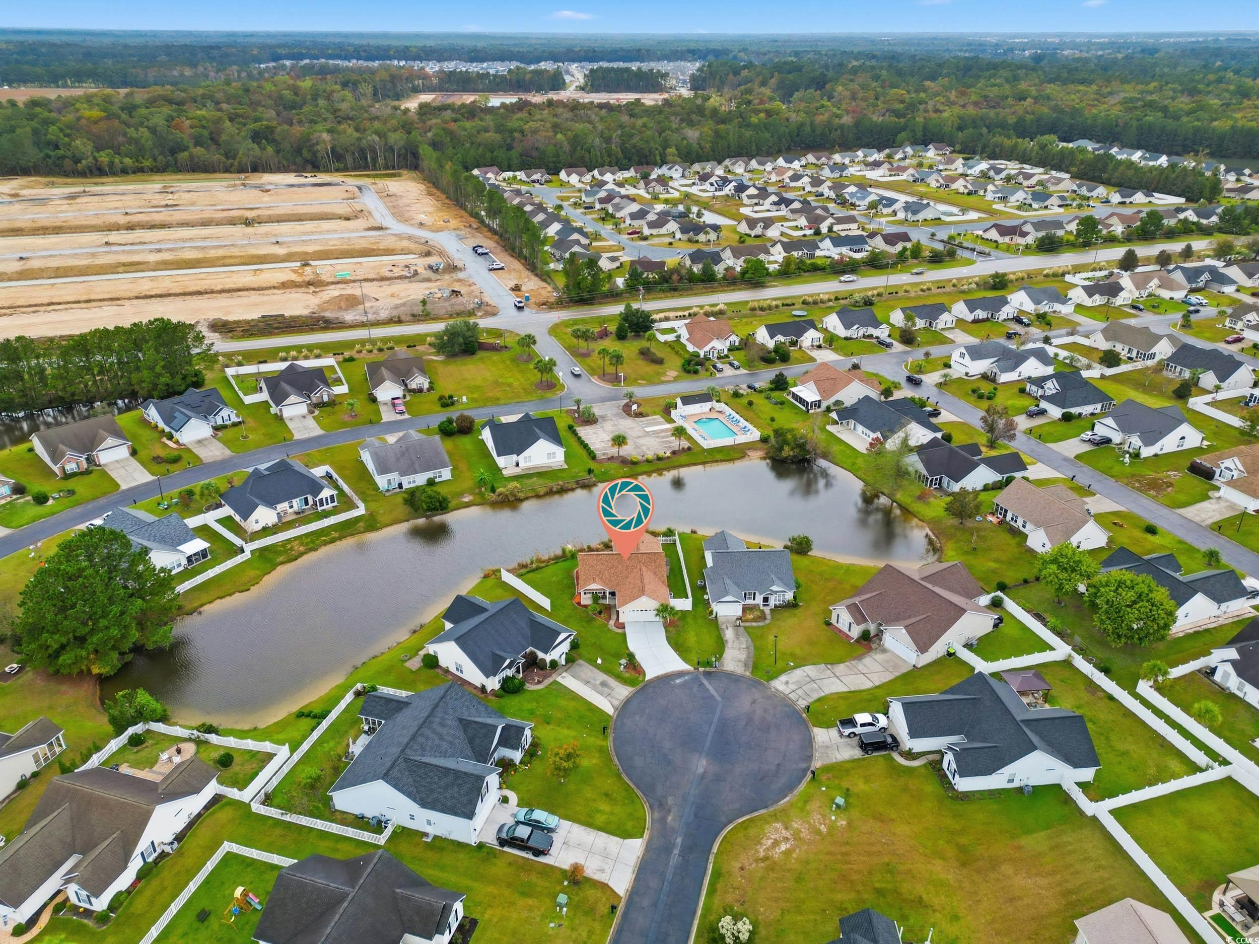 Aerial view of property's location with nearby suburban area and a nearby body of water