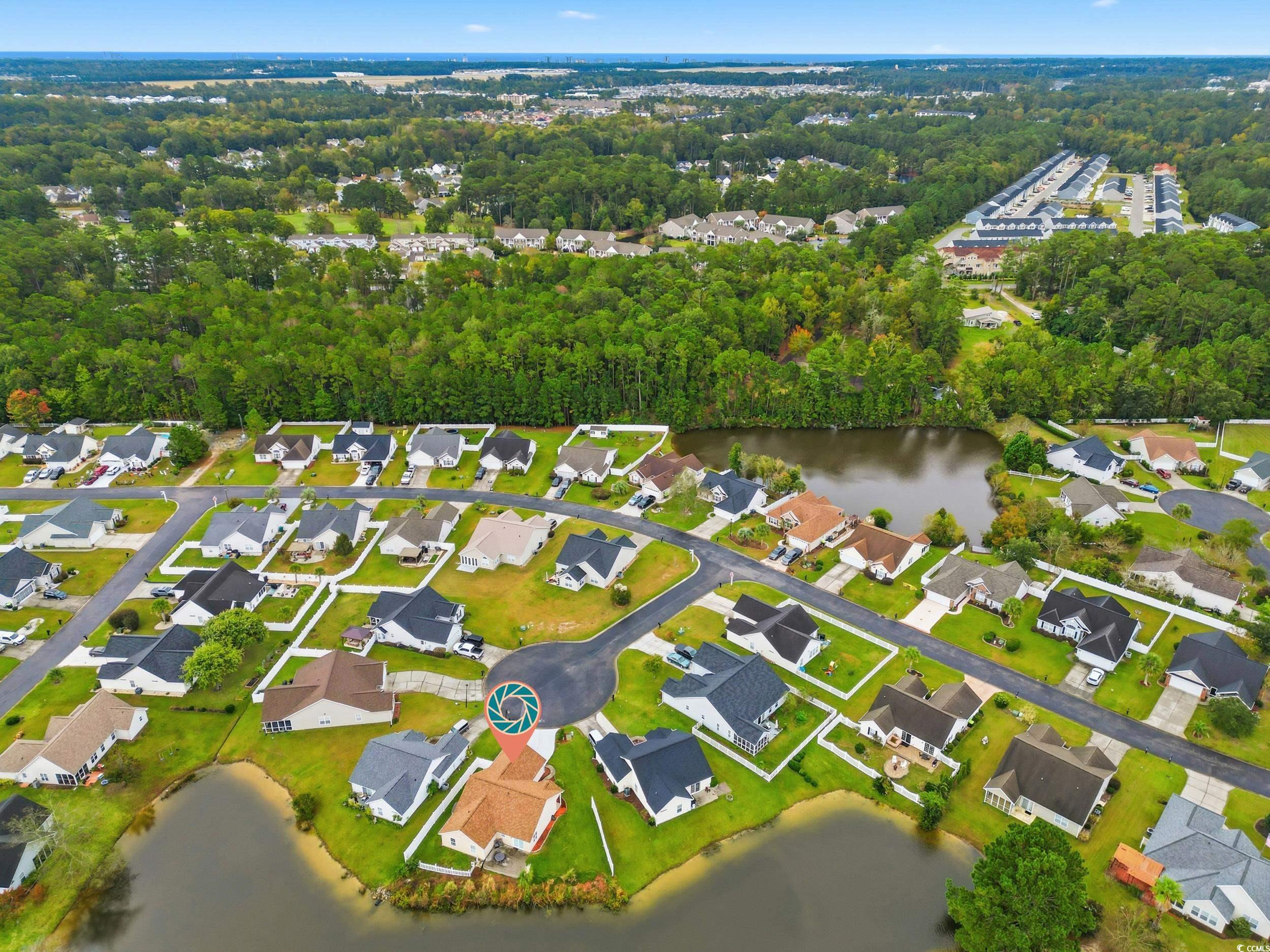 Aerial overview of property's location with a nearby body of water and nearby suburban area