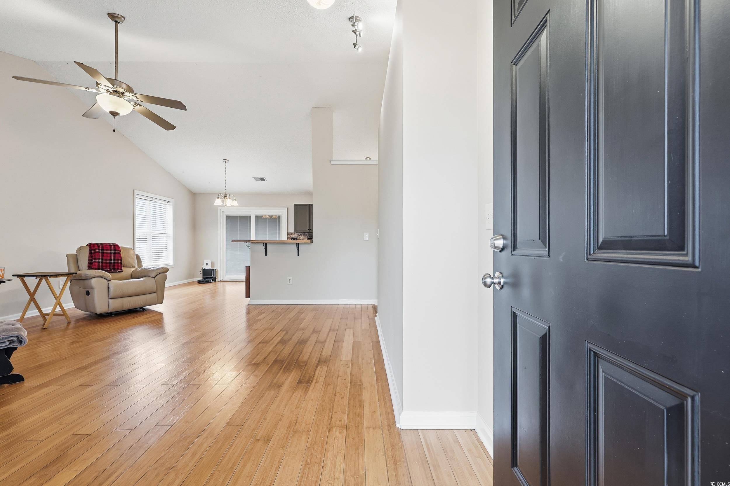 Foyer entrance featuring light wood-style floors, ceiling fan, and high vaulted ceiling