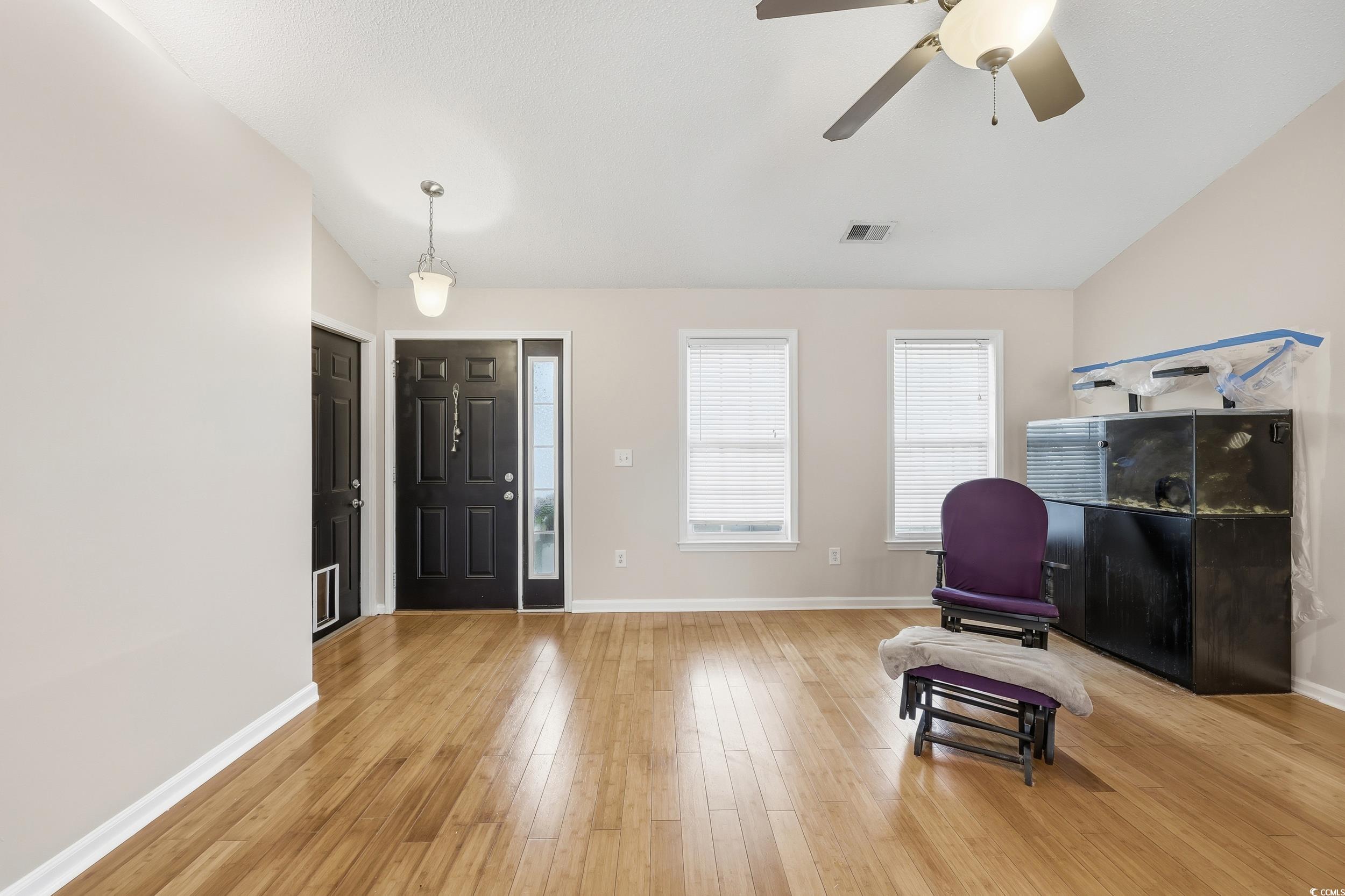Entrance foyer featuring light wood-style flooring, lofted ceiling, and a ceiling fan