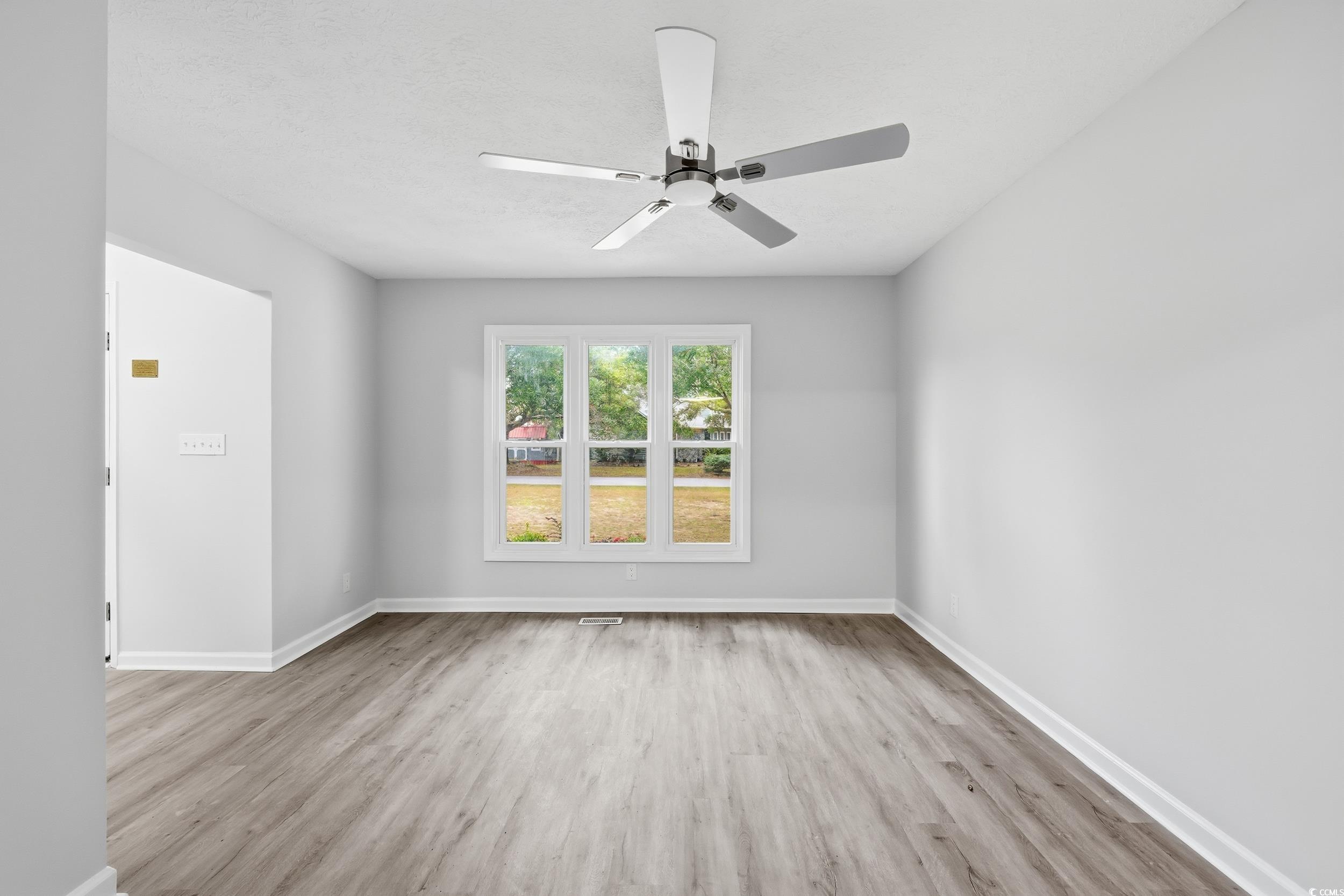 Empty room with light wood-style flooring and a ceiling fan