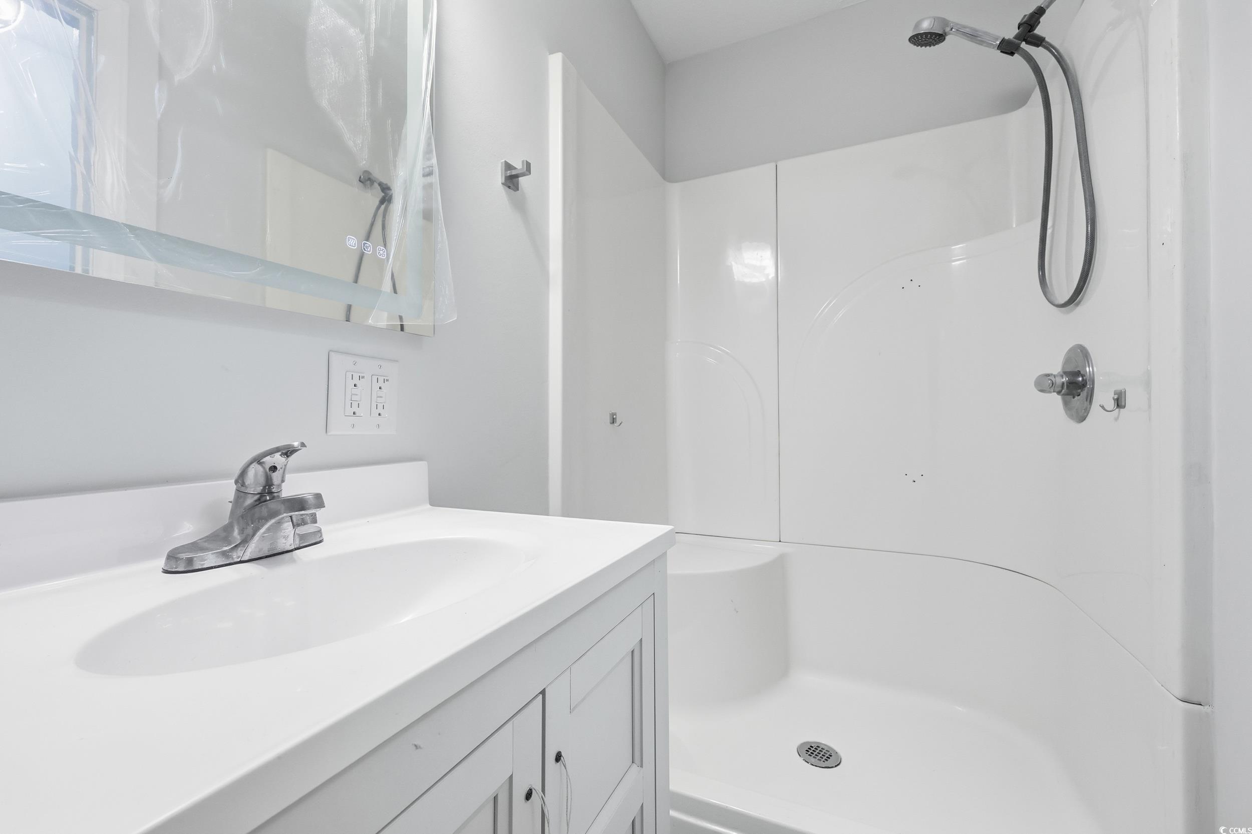Bathroom featuring vanity and a shower