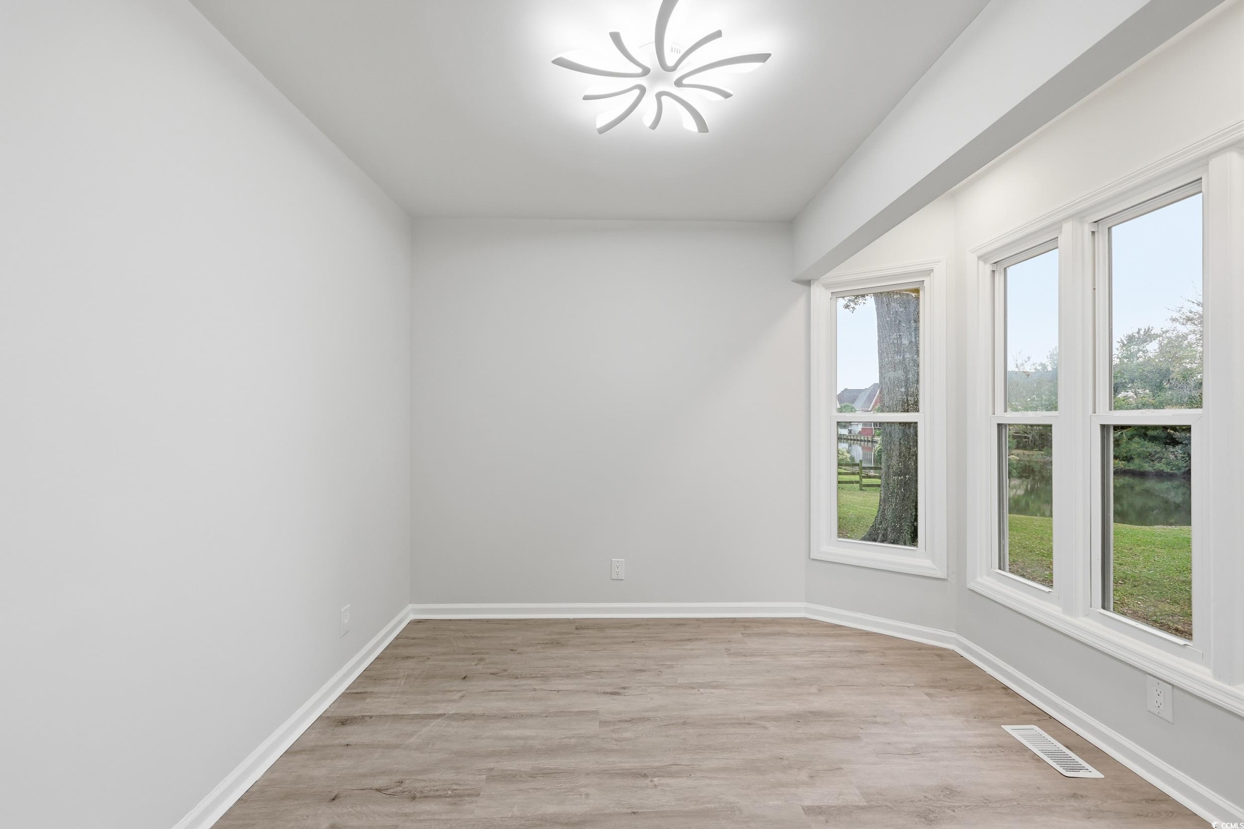 Unfurnished room featuring light wood finished floors and baseboards