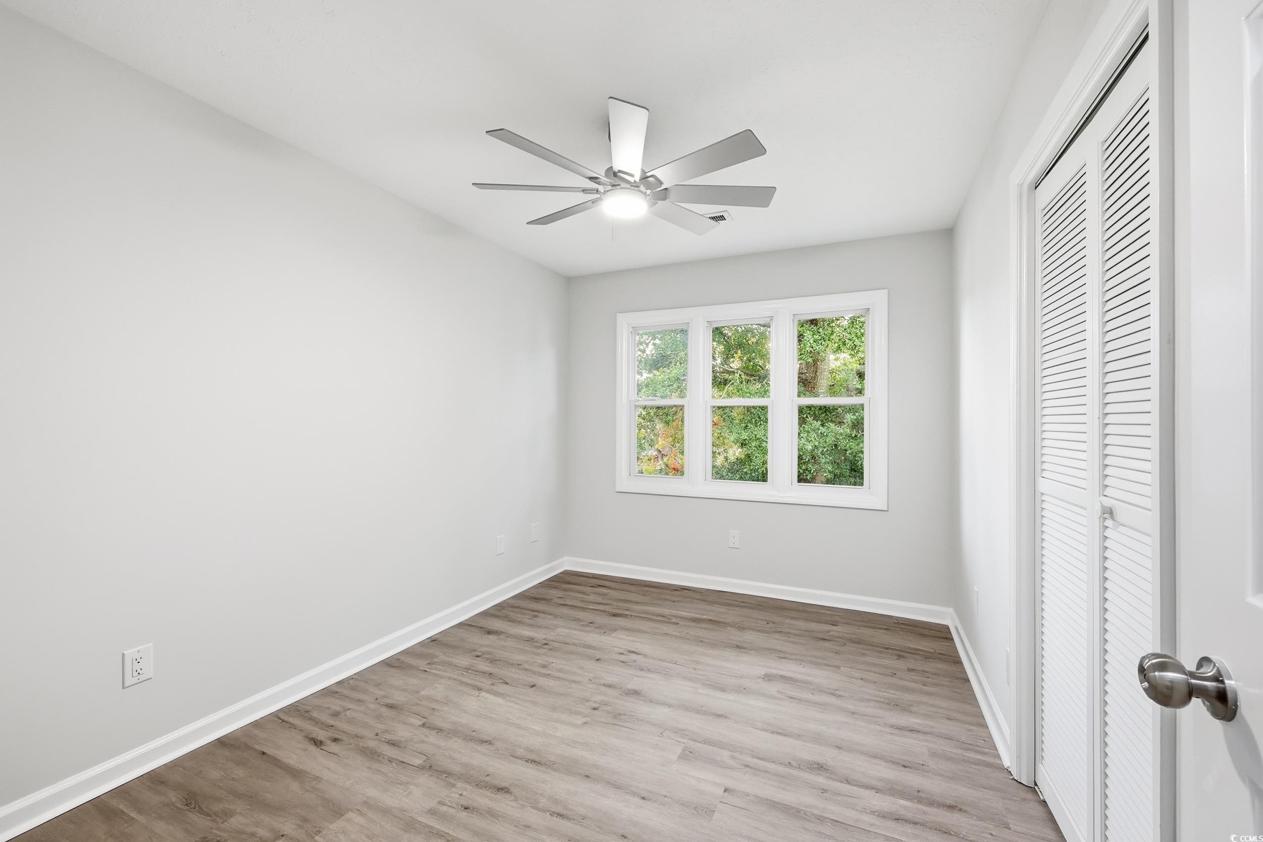 Unfurnished bedroom with a closet, light wood-style flooring, and a ceiling fan
