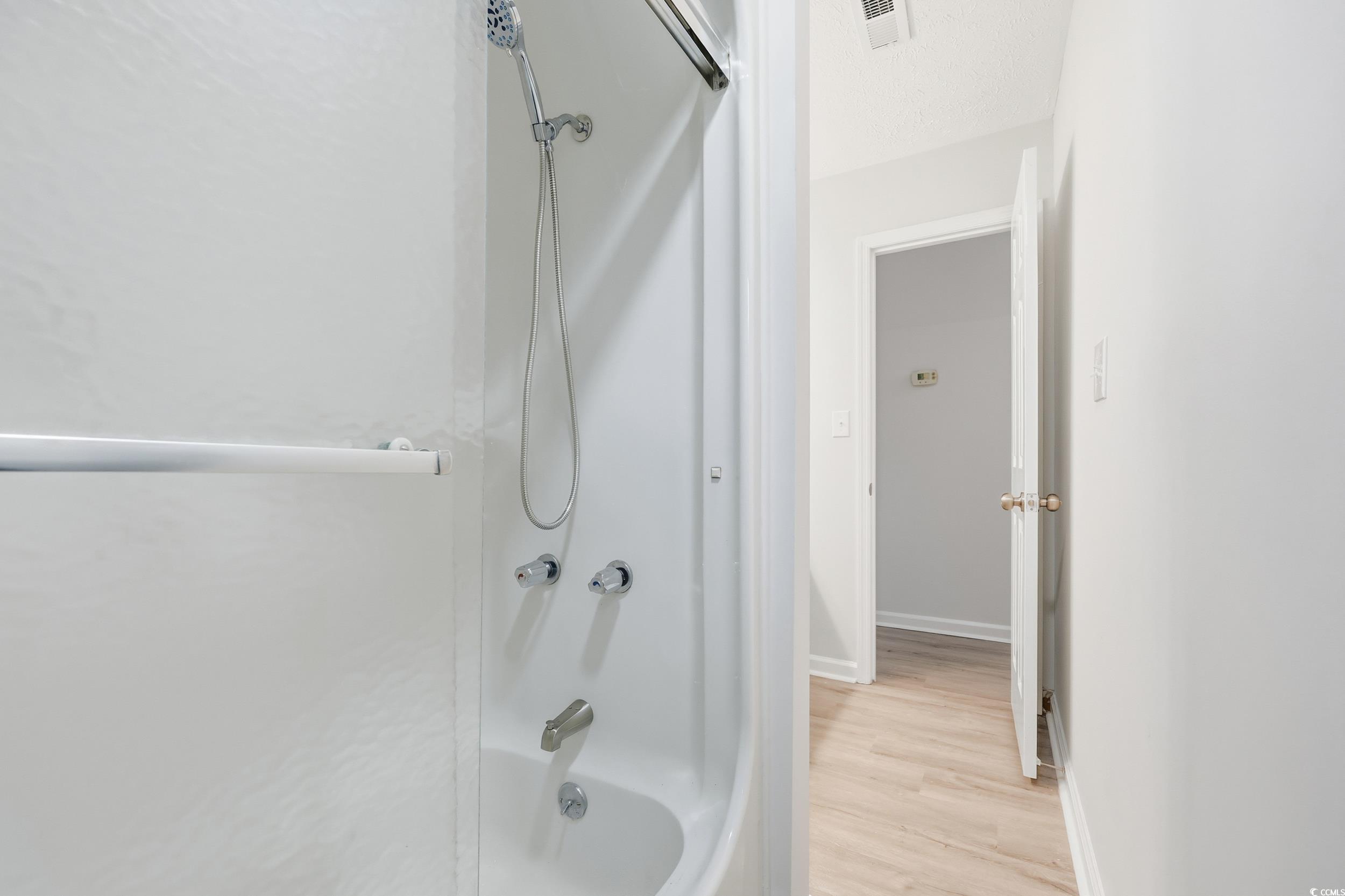 Bathroom featuring shower / tub combination and light wood-style floors