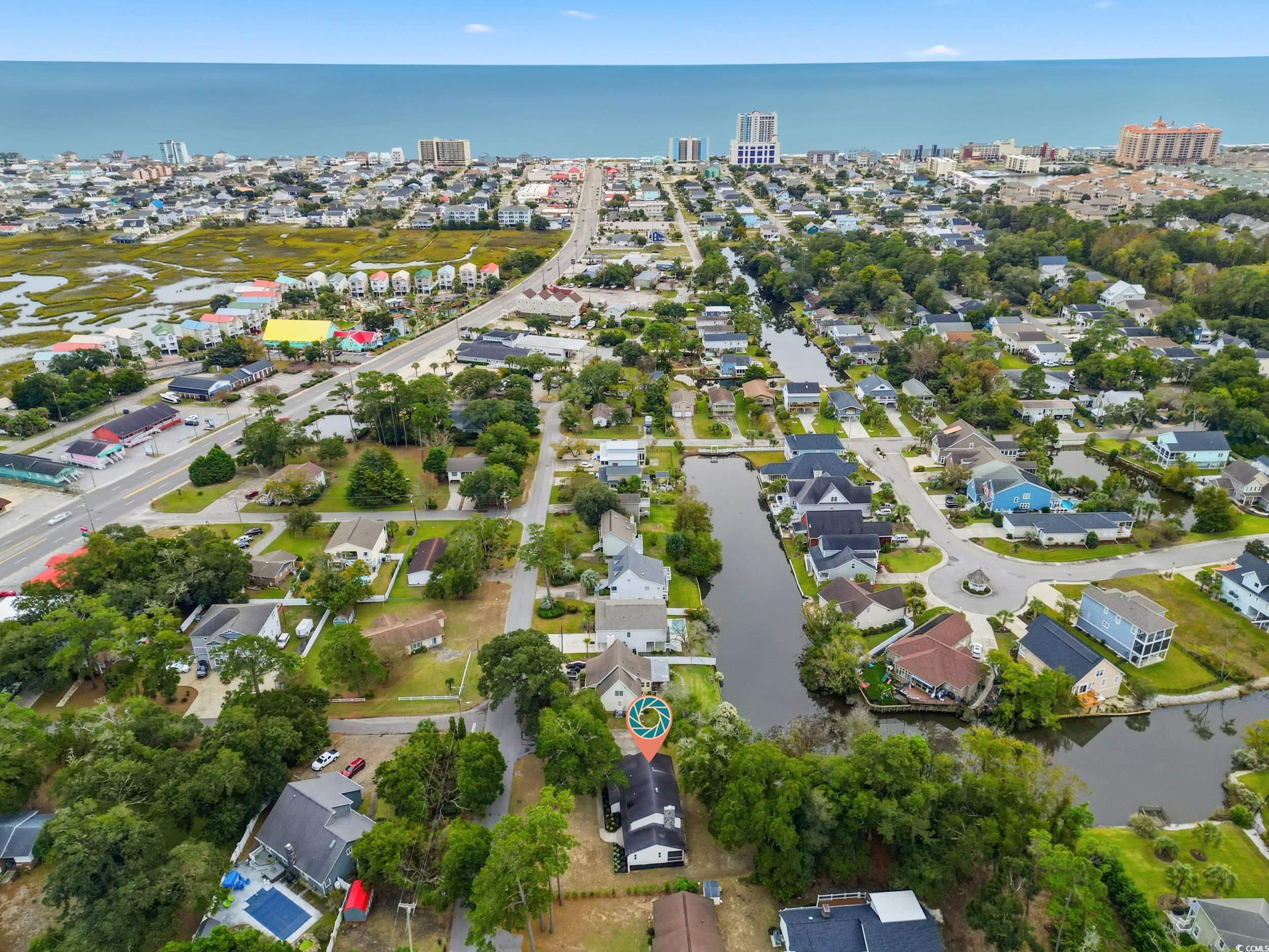 Aerial view of property and surrounding area featuring a large body of water and nearby suburban area