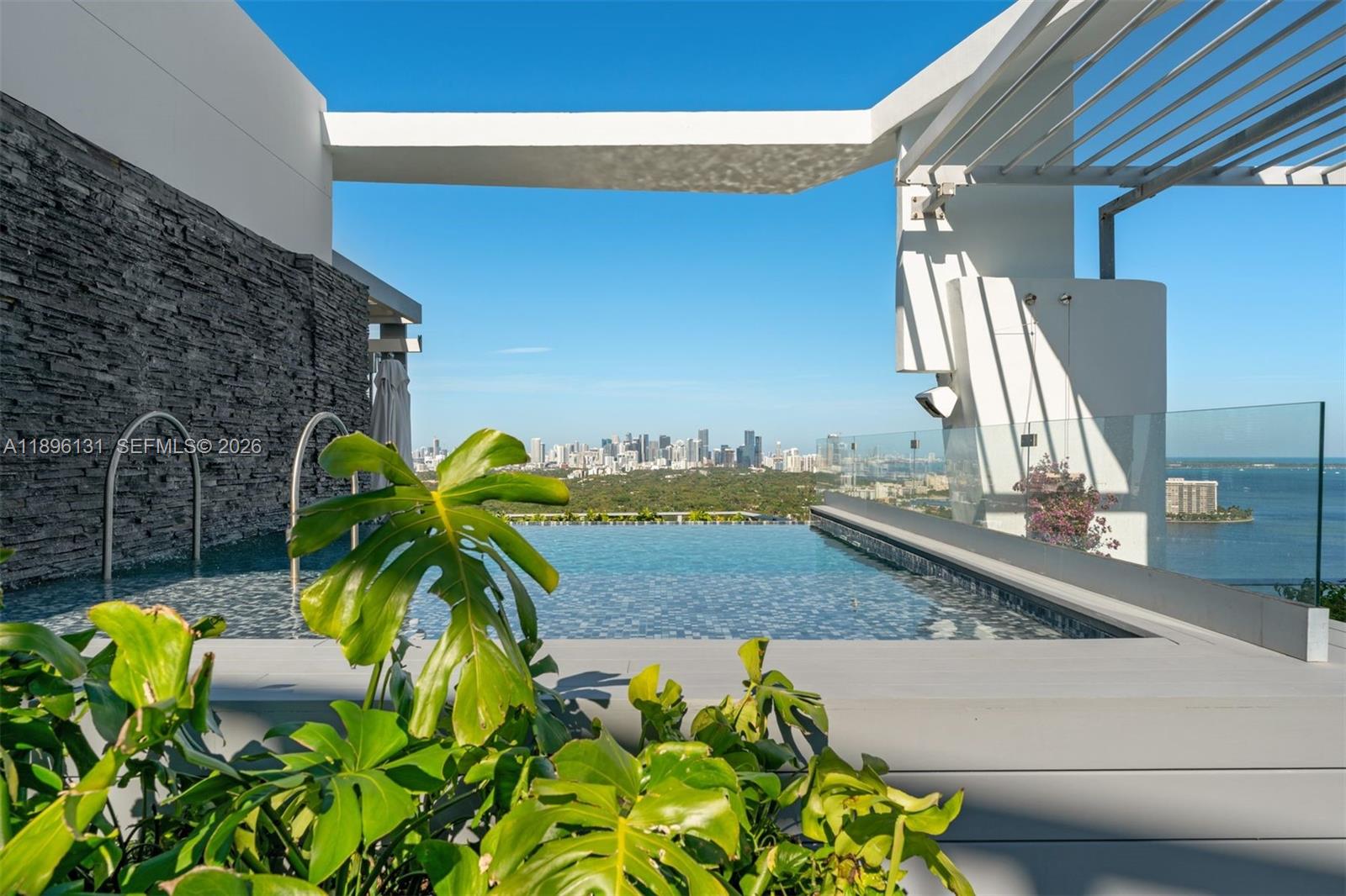 Soaring above Coconut Grove, this 11,810 SF penthouse at Grovenor House embodies the pinnacle of modern luxury. A private rooftop pool crowns this 5-bedroom, 5.2-bath residence, offering stunning 360° views of Biscayne Bay and the glittering Miami skyline. Designed for both elegance and ease, the home features tray ceilings, custom millwork, rich hardwood and black chalk marble floors, a 300+ bottle wine cellar, and a bespoke gourmet kitchen. Walls of glass open to a wraparound terrace, blurring the line between indoors and out. With a private elevator, rooftop summer kitchen with food lift, automated shades, and integrated smart home technology, this is elevated living at its finest.