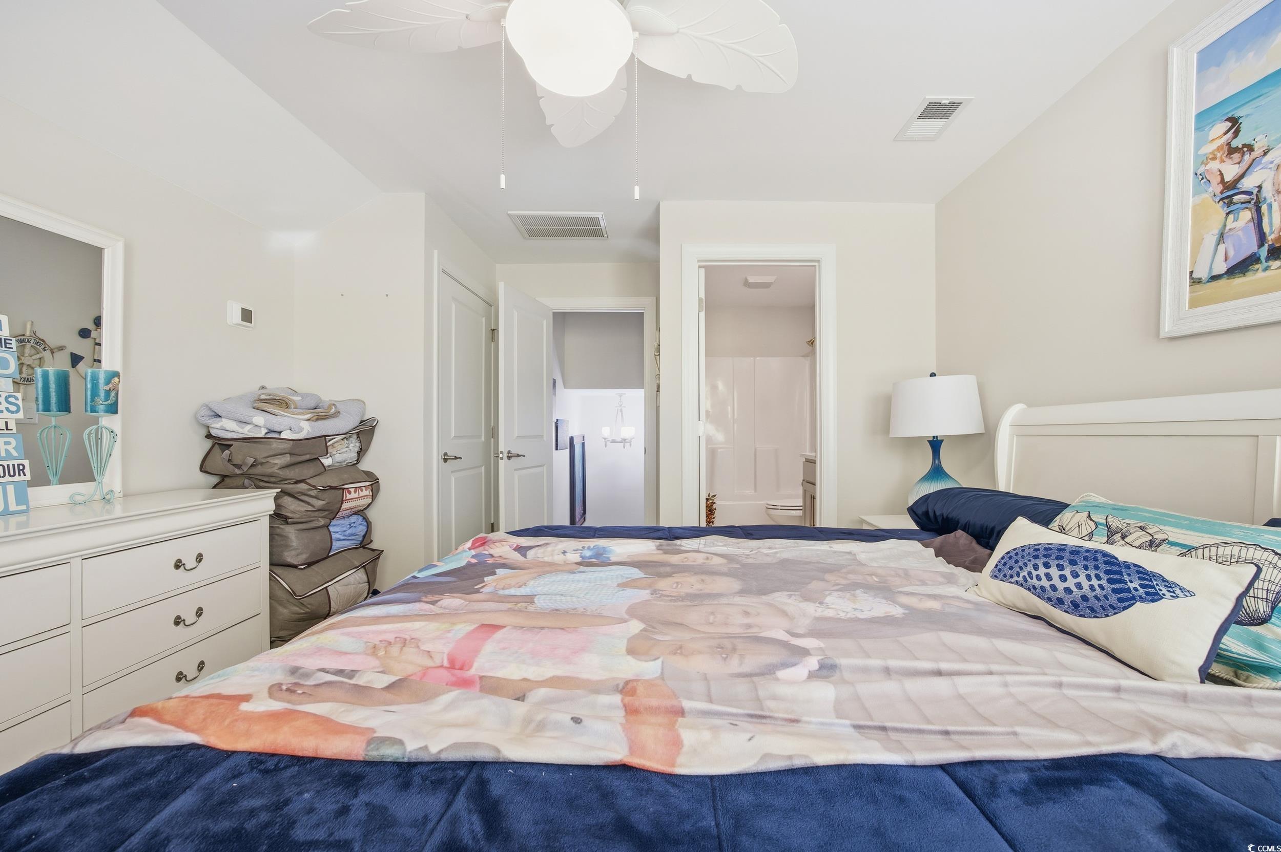 Bedroom with ensuite bath and a ceiling fan
