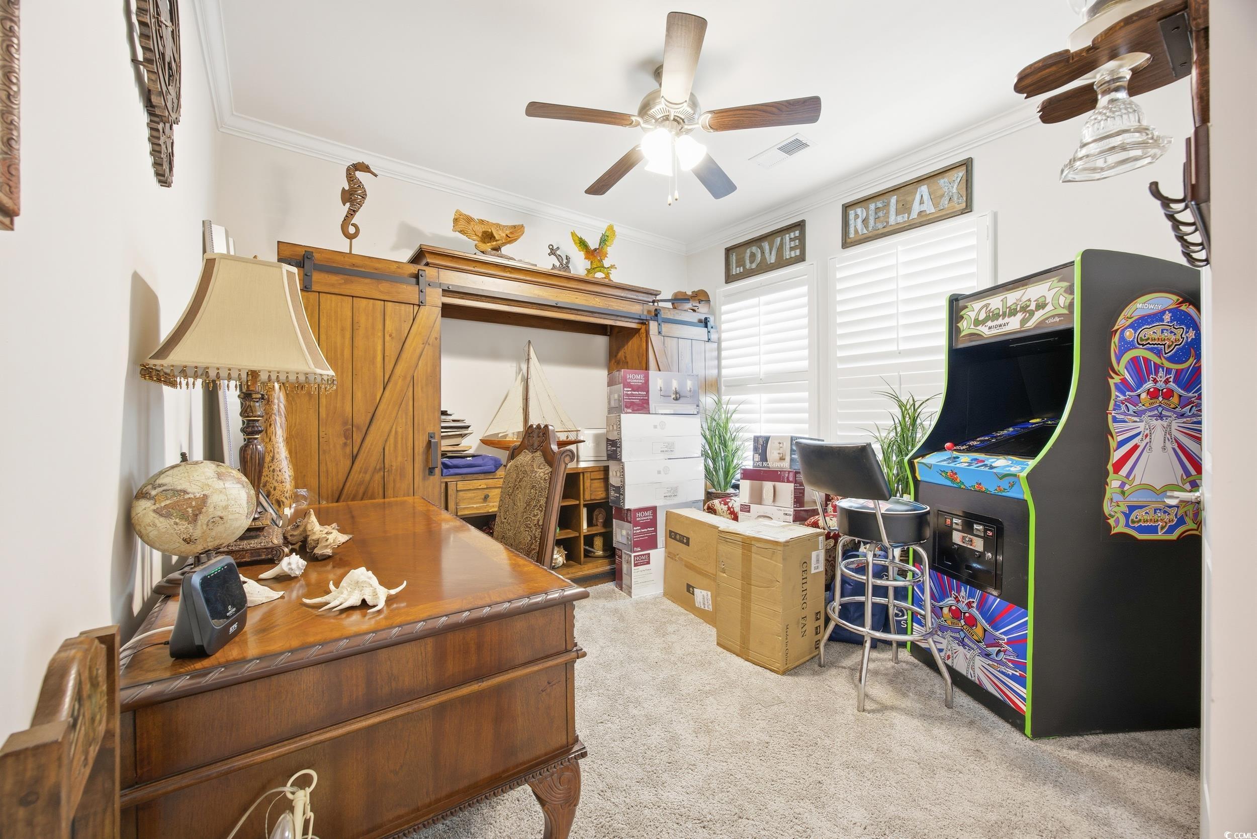 Office with crown molding, light colored carpet, and ceiling fan