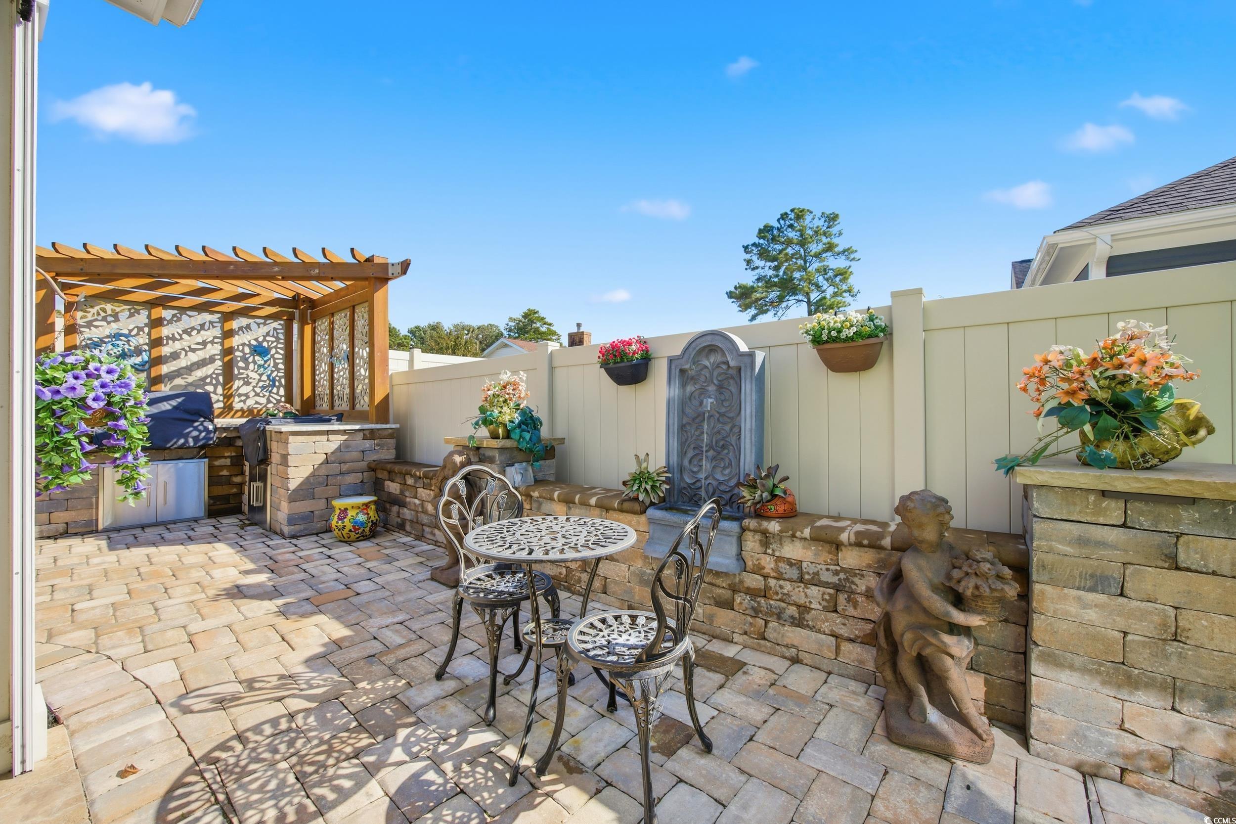 Fenced backyard with a patio area, a pergola, grilling area, and outdoor dining area