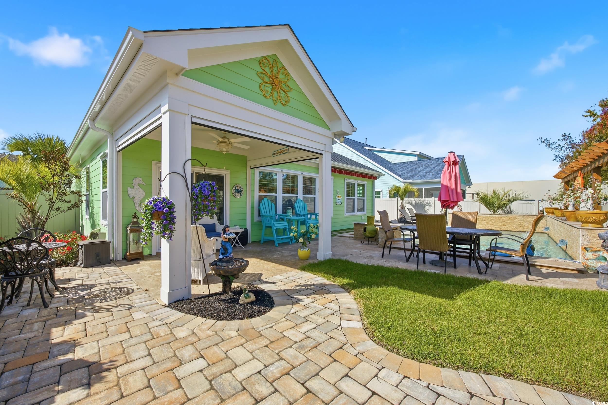 Fenced backyard featuring a patio, outdoor dining area, and a ceiling fan