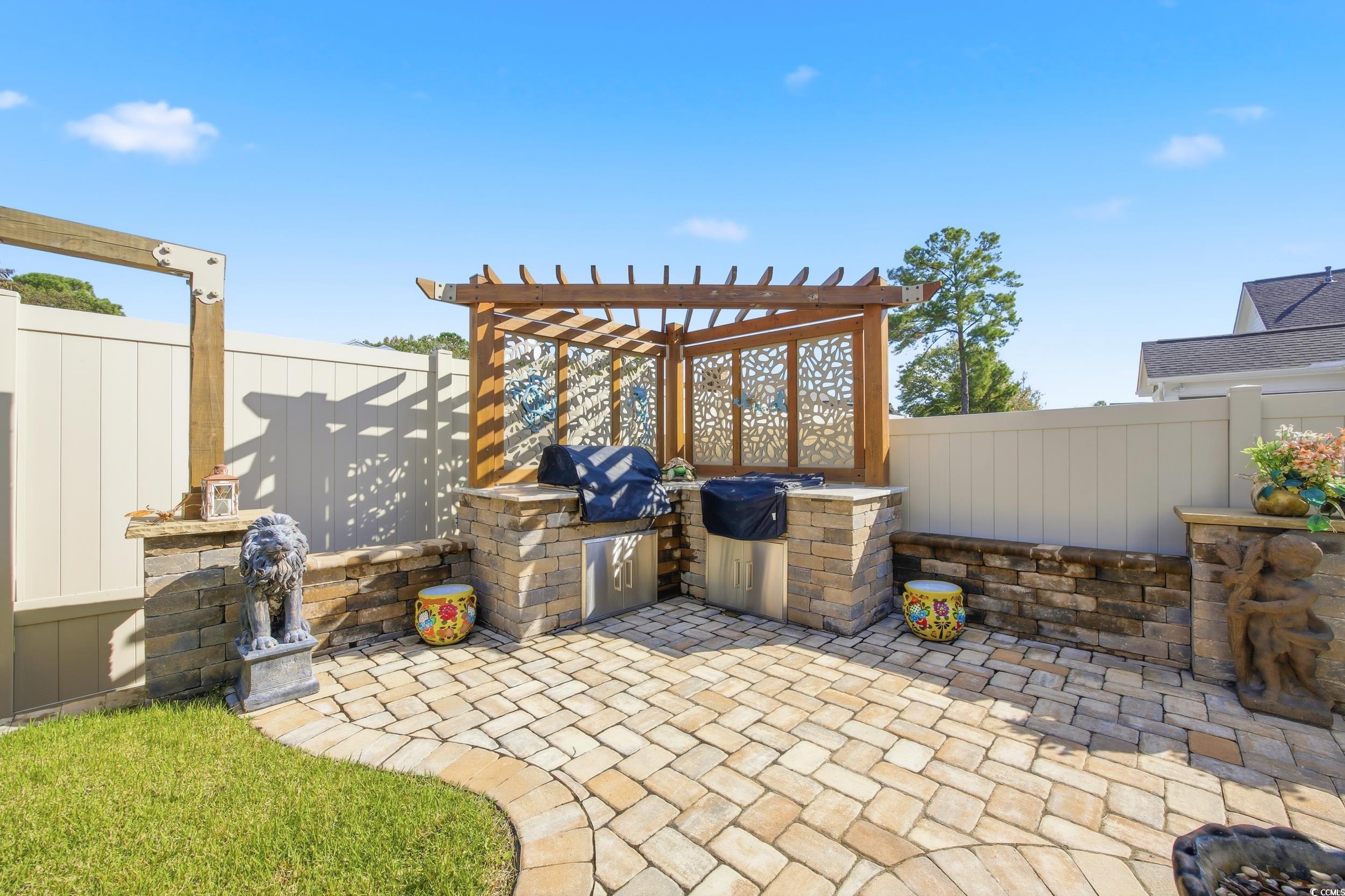 Fenced backyard with a patio, a pergola, and a grill