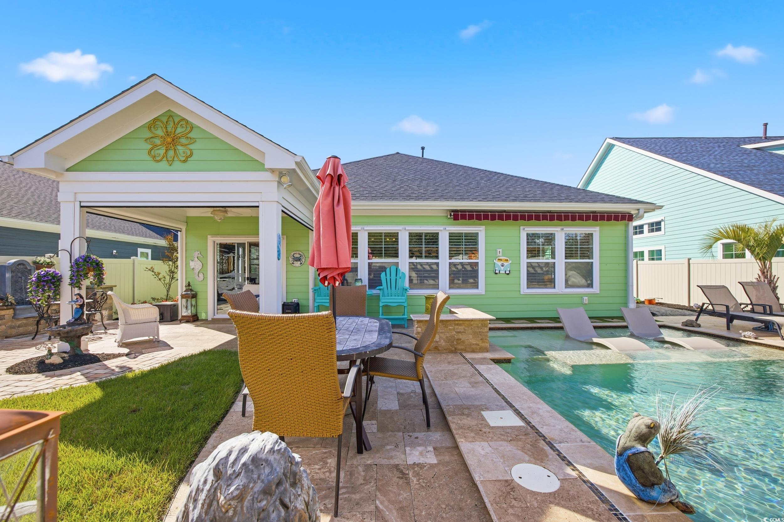 Back of house featuring a patio, an outdoor pool, roof with shingles, and outdoor dining area
