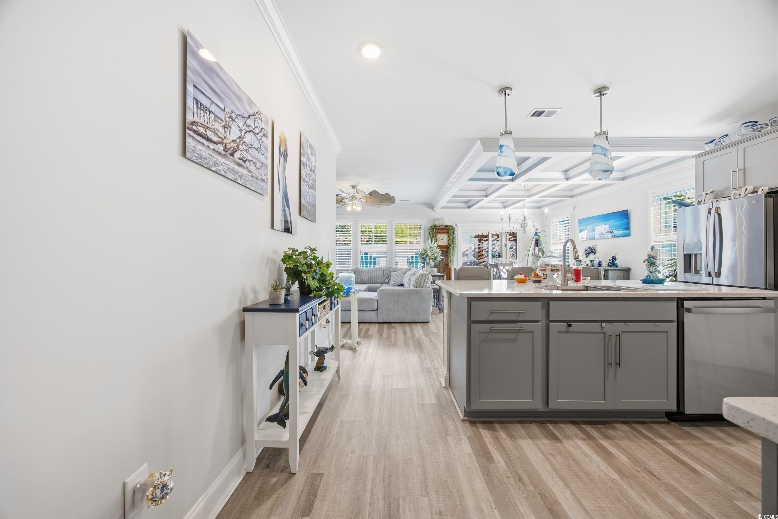 Kitchen with coffered ceiling, open floor plan, ornamental molding, ceiling fan, and gray cabinetry