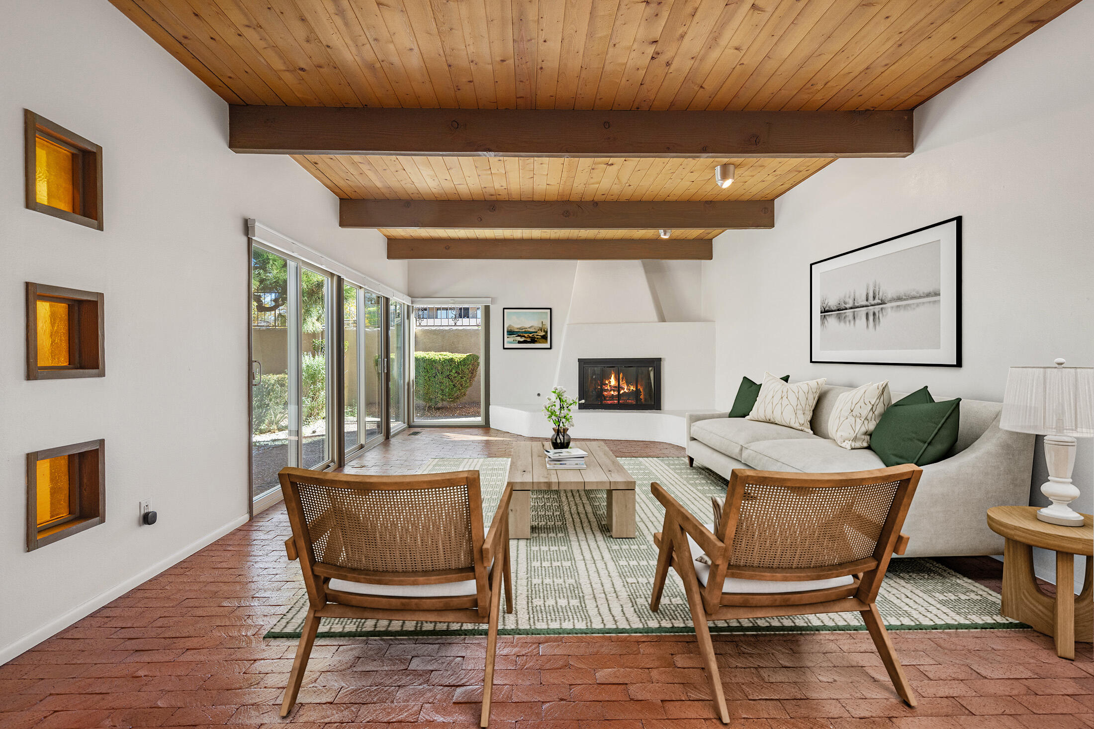 You'll love this mid-century modern townhome in the heart of Nob Hill and UNM--stylish, spacious, and easy to live in. Featuring 3-4 bedrooms and 2.5 baths, it offers generous rooms, brick floors, beamed ceilings, and a kiva-style fireplace. The dining room's custom mural adds charm, while the kitchen includes ample storage and a bright breakfast nook. Upstairs, enjoy Sandia Mountain views from the primary suite with dual sinks. The lower level features a study/library with fireplace, bonus storage, and oversized 2-car garage. Tankless water heater and foam roof with transferable warranty included. The bedrooms have new Pella double pane windows. Retro style meets modern comfort in one of Albuquerque's great neighborhoods, near tons of restaurants, shopping, UNM and the Co-op!