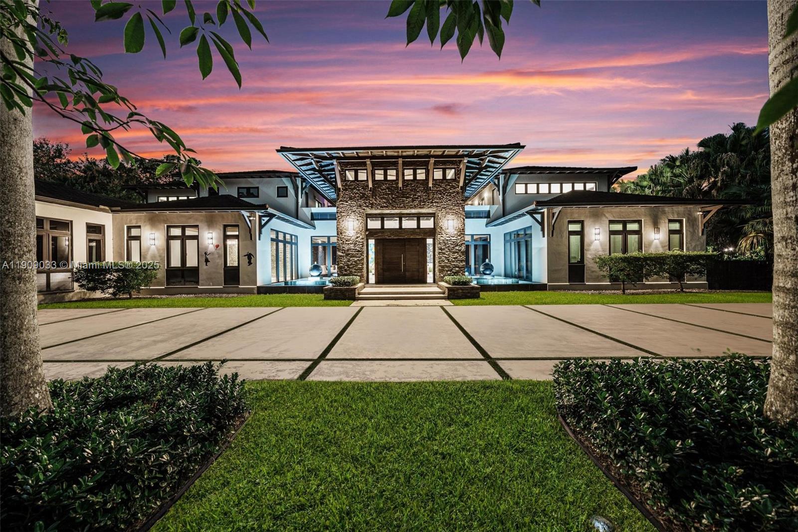 Welcome to The Sanctuary at Pinecrest, a private haven of modern elegance and timeless design. This gated estate offers approx. 11,300 SF of living space on a 1.16-acre lot with 7 bedrooms and 11 baths, including two luxurious primary suites. Soaring ceilings, walls of glass, and refined finishes define the interiors, featuring a chef’s kitchen, formal and casual living areas, gym, media room, office, and guest quarters. Outdoors, enjoy an infinity-edge pool, summer kitchen, covered terraces, private tennis court, and two fountains framing the main entrance. Complete smart-home automation, elevator, and lush tropical landscaping enhance this architectural masterpiece.